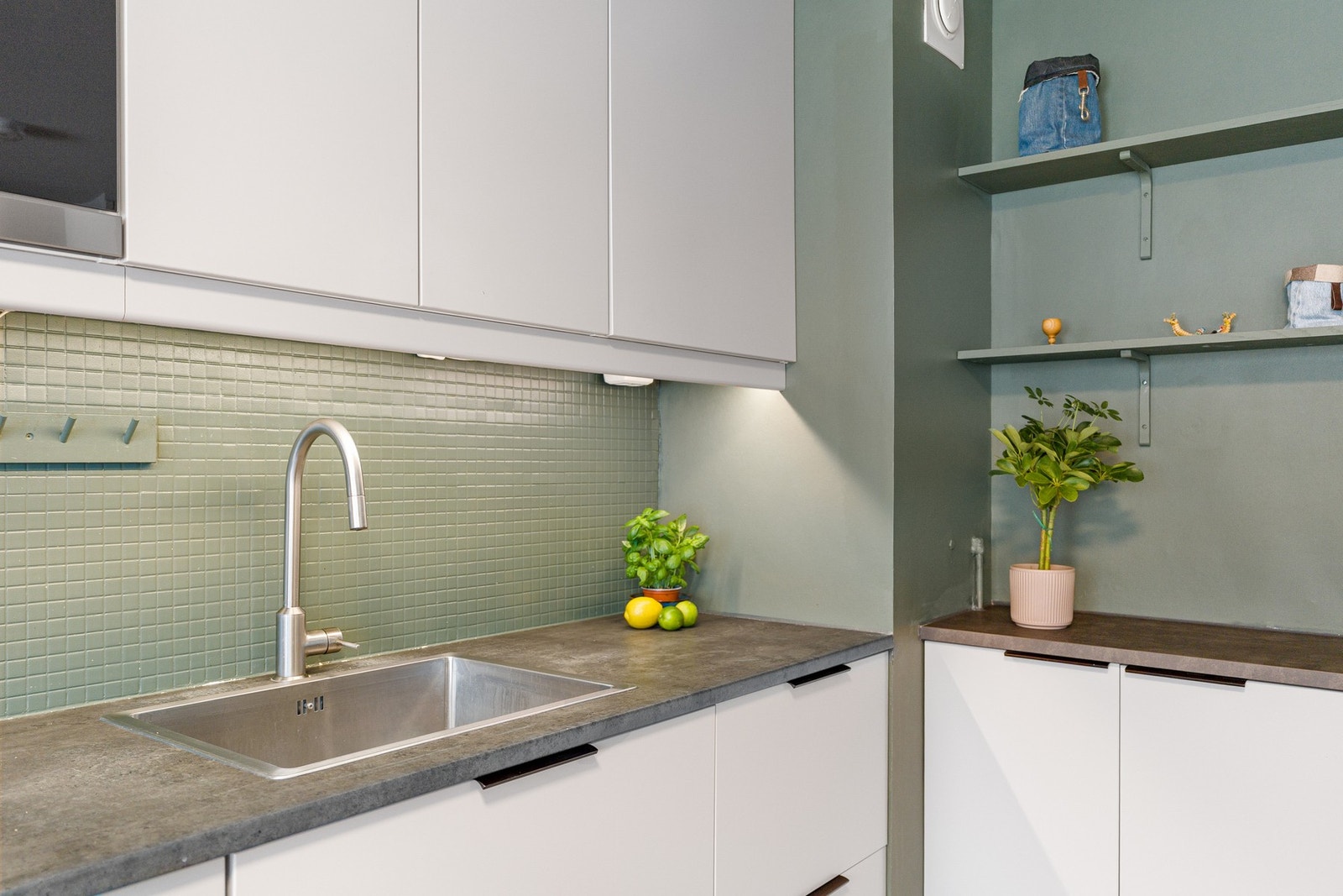 Integrerte hvitevarer på kjøkken som stekeovn, platetopp, mikrobølgeovn og oppvaskmaskin. Galleribilde