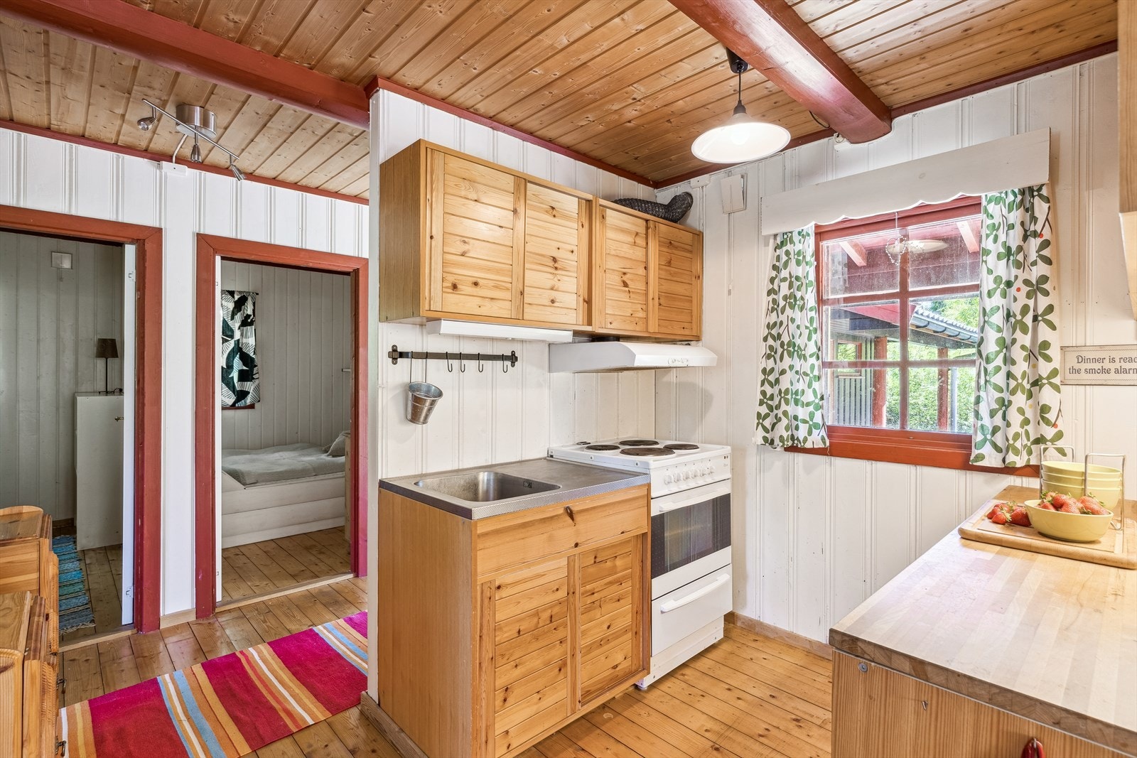 Kjøkkeninnredning med profilerte fronter, heltre benkeplate og oppvaskkum i rustfritt stål. Galleribilde