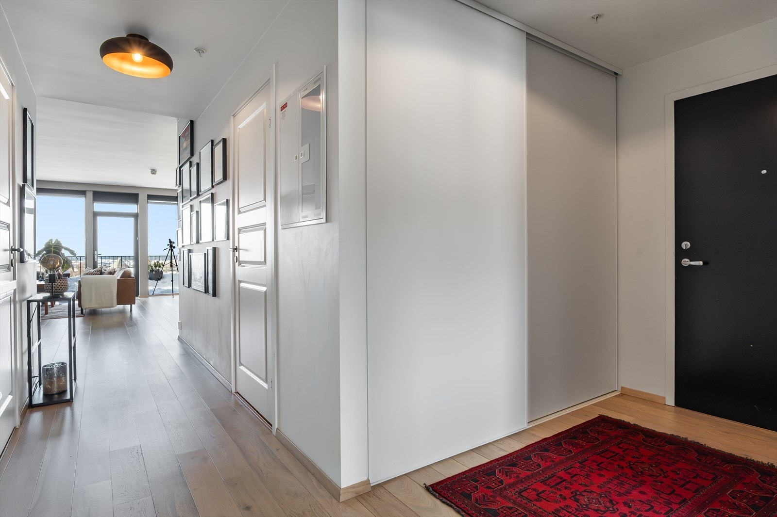 Lys og romslig entré med god oppbevaringsplass i praktisk skyvedørsgarderobe Galleribilde