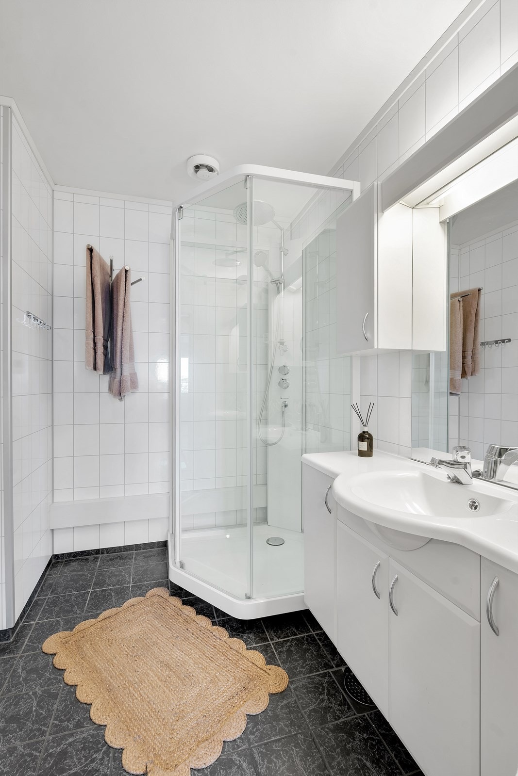 Flott bad med flislagt gulv med varmekabler og praktiske baderomsinnredninger. Galleribilde