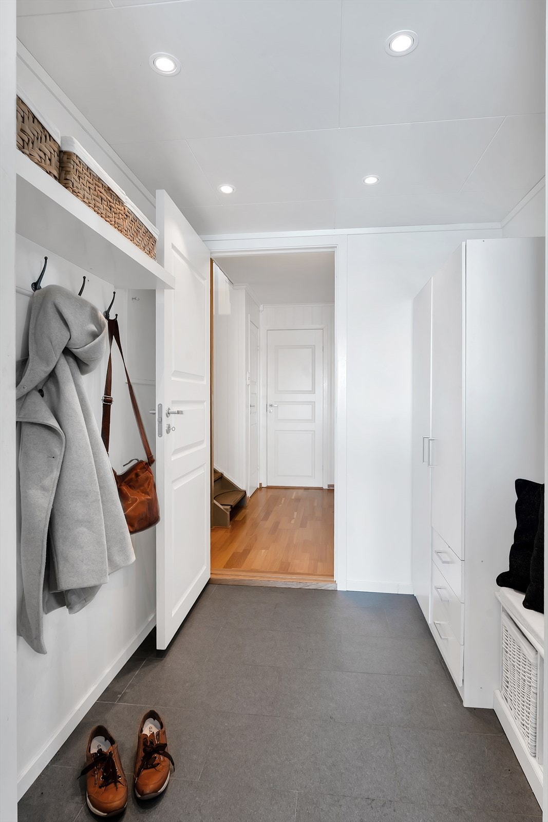 Velkommen inn! Romslig flislagt gang med gode oppbevaringsløsninger både på hyller og i garderobeskap. Galleribilde