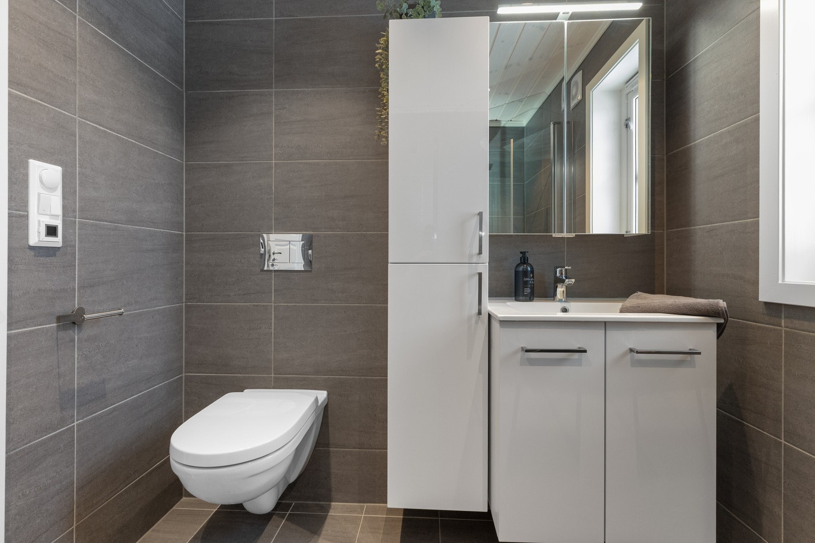 Hvit innredning med nedfelt servant. Høyskap samt speilskap Galleribilde