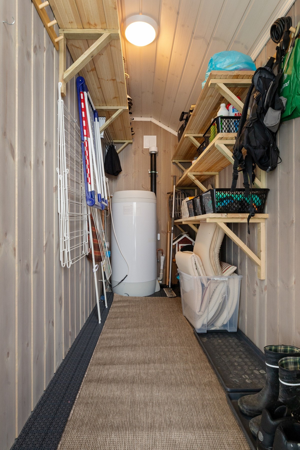 Boden er praktisk innredet med hyller og knagger for oppbevaring Galleribilde