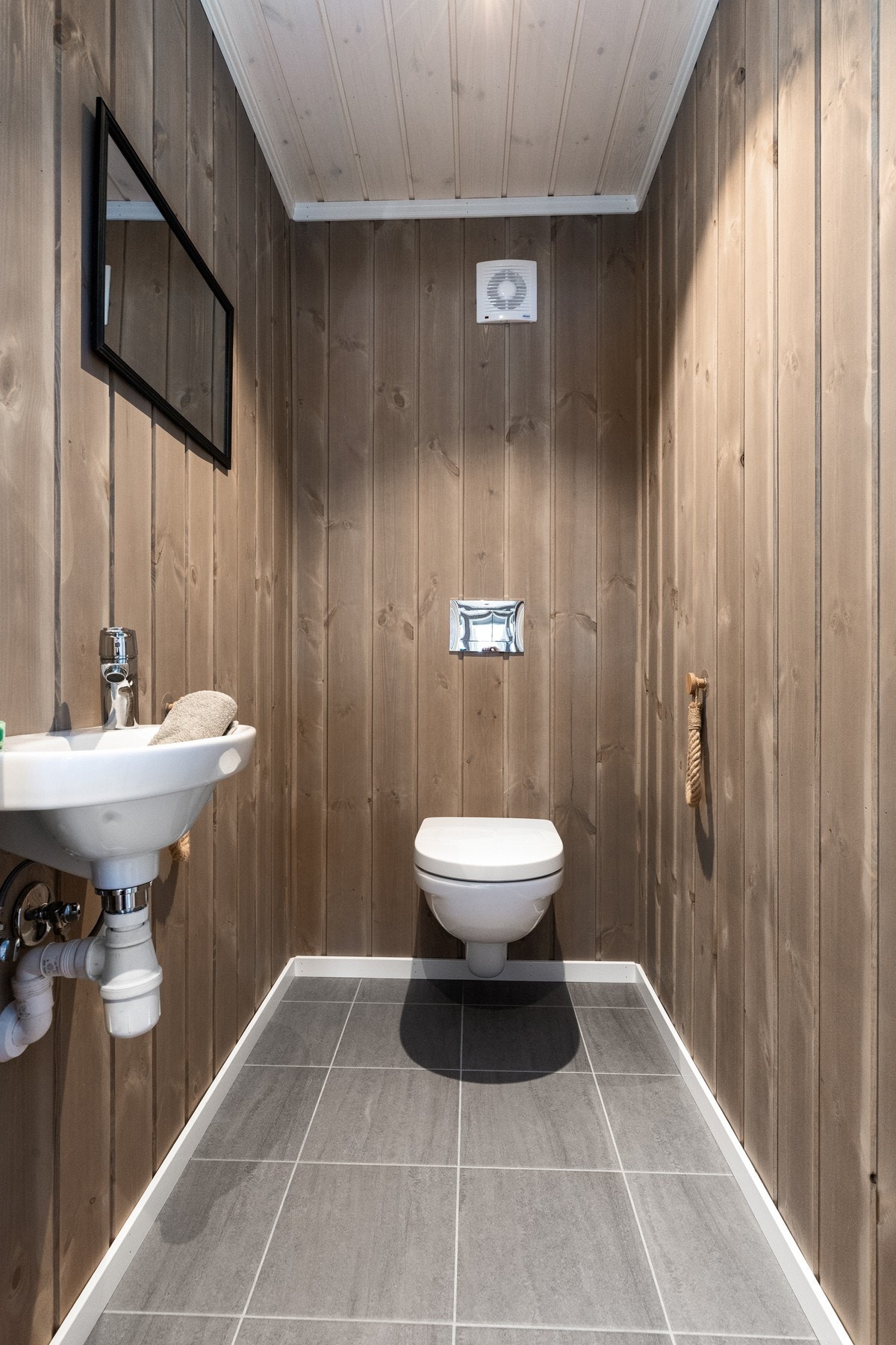 Toalettrom med panel på vegger. Fliser og varmekabler på gulv Galleribilde