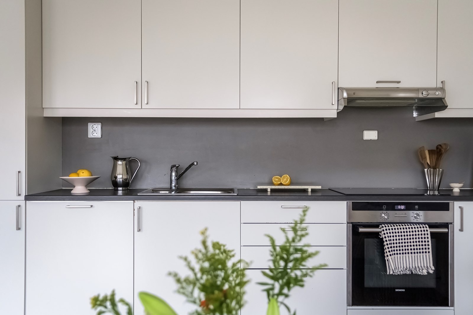 Tidløst Sigdal kjøkken med integrerte hvitevarer som induksjon platetopp, stekeovn, oppvaskmaskin og kjøl/frys. Galleribilde