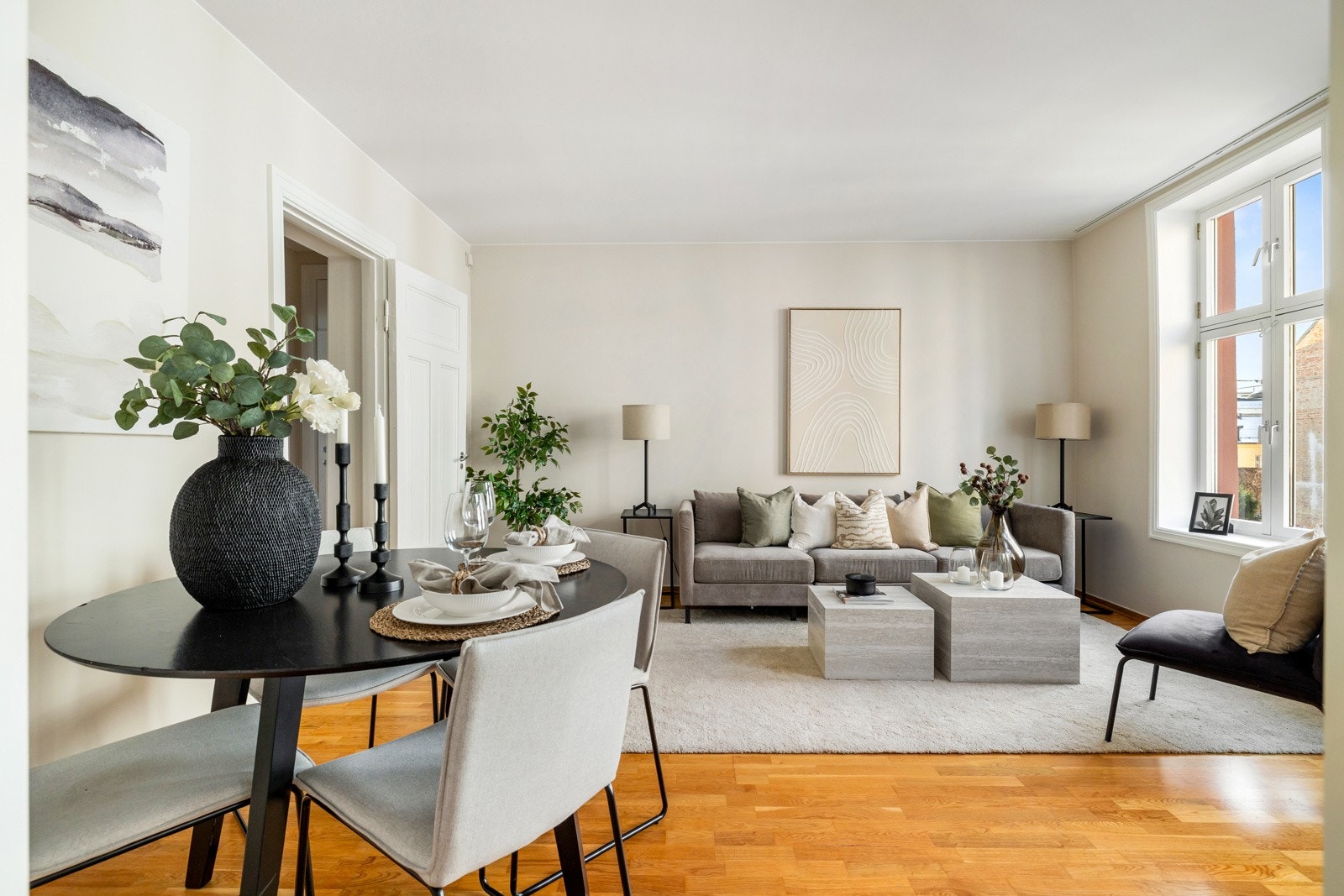 Stuen har en lys atmosfære med store vindusflater, samt lysmalte vegger og parkett på gulv Galleribilde