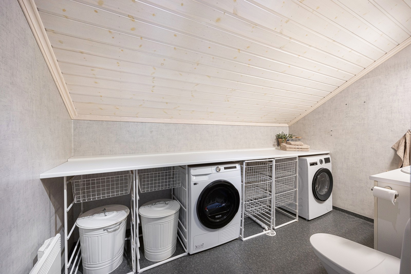 Vaskerommet er praktisk organisert med en god arbeidsbenk med kurvhyller under, samt opplegg for vaskemaskin og tørketrommel. Galleribilde