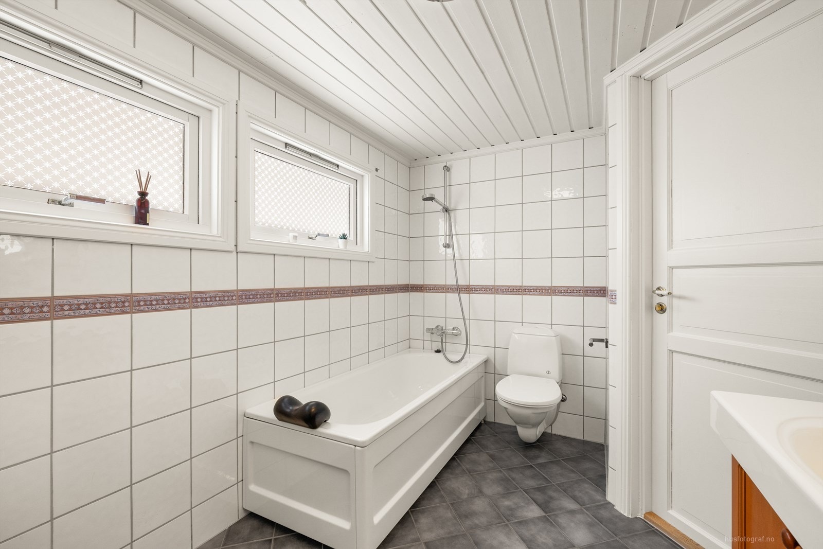 Hovedbadet i 2.etasje er flislagt med stor servantinnredning som har dobbelservant, vegghengt toalett og badekar med dusjarmatur. Galleribilde