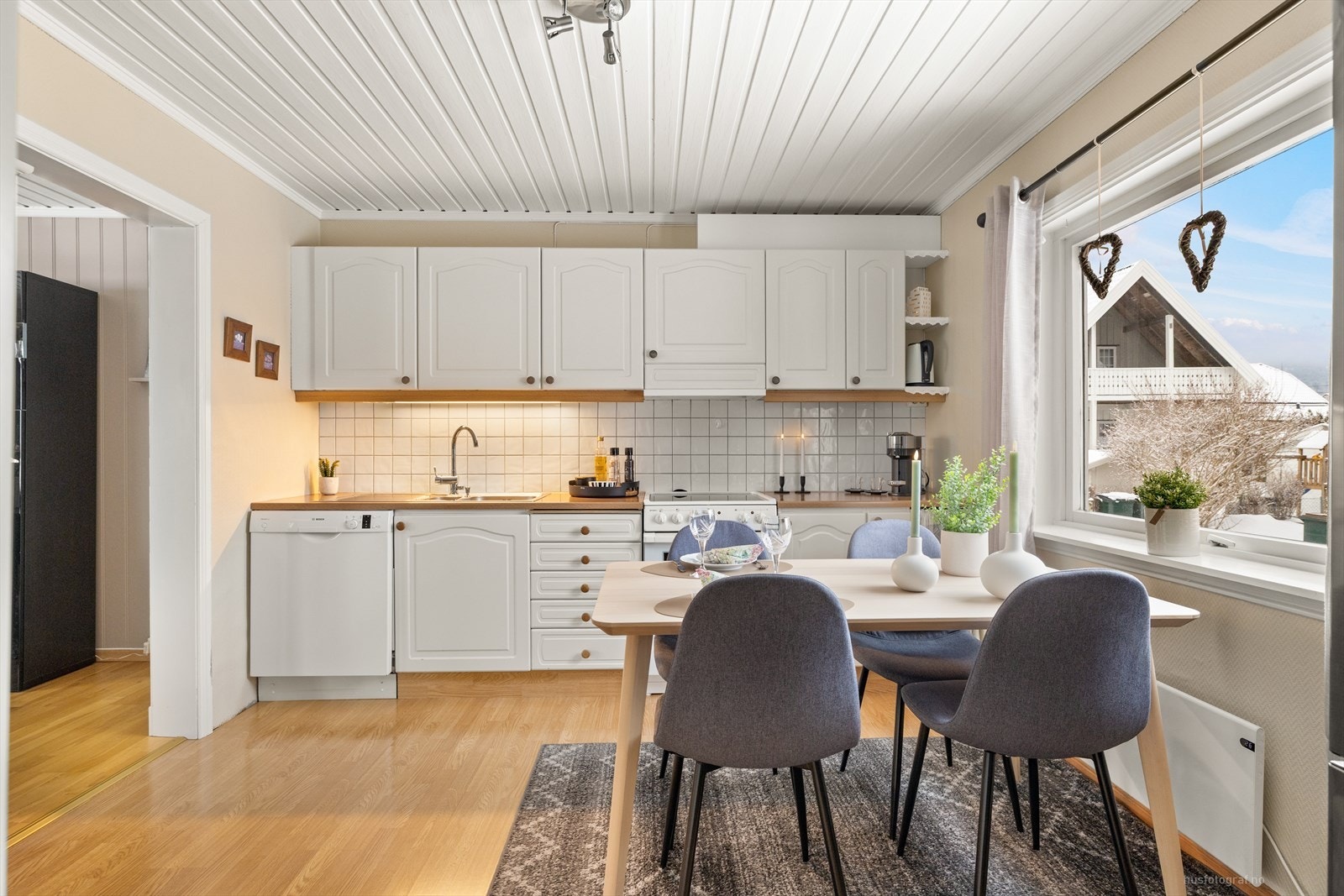 Klassisk kjøkkeninnredning med profilerte, hvite fronter. Galleribilde