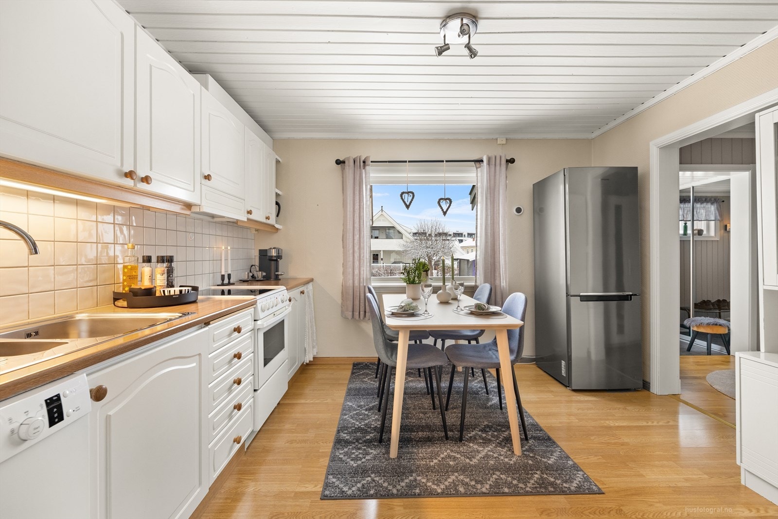 Kjøkkenet har rikelig med oppbevaringsplass, samtidig som det gir rommet en luftig og åpen følelse. Benkeplate i laminatutførelse, med nedfelt oppvaskkum. Galleribilde