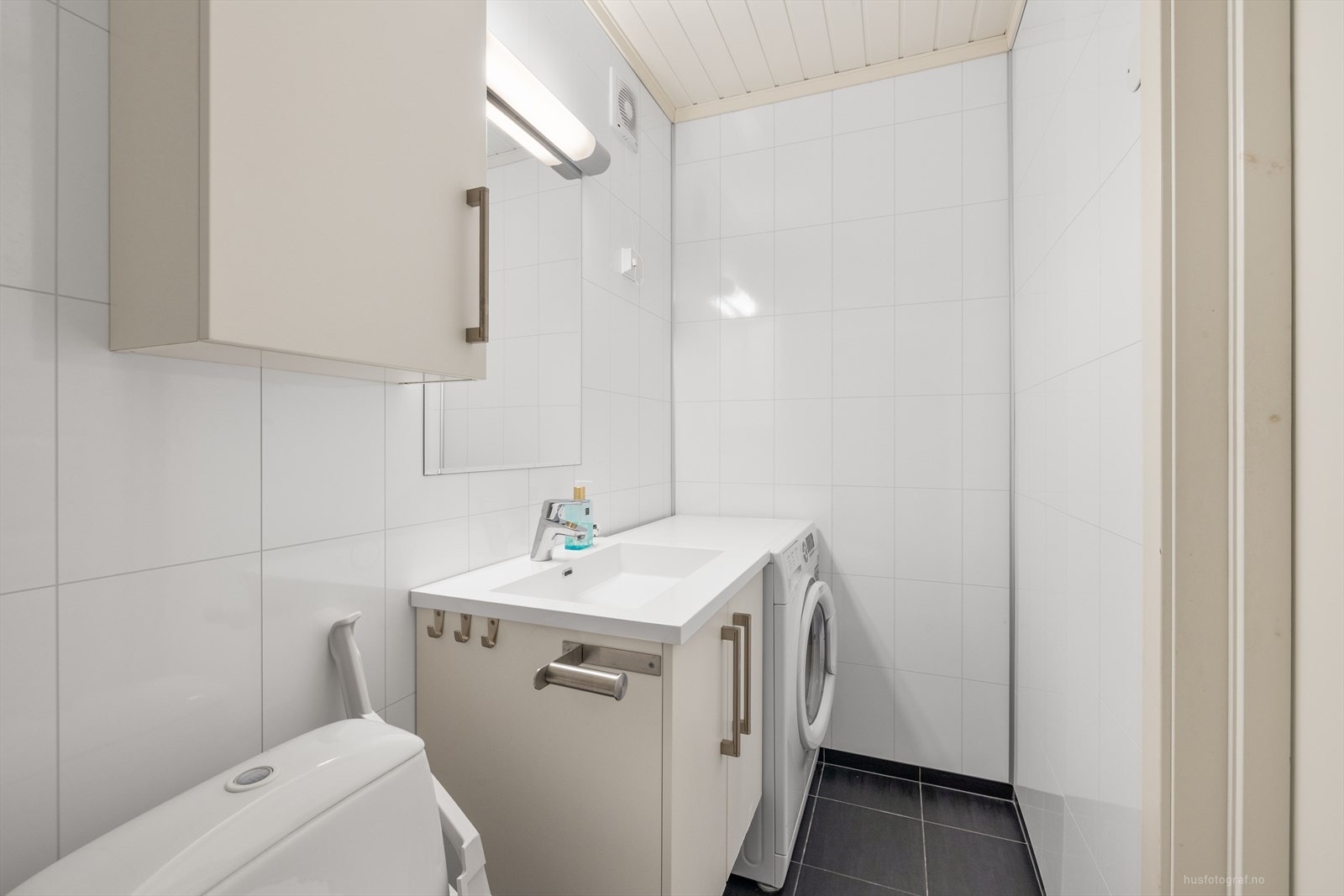 Badet er utstyrt med dusjhjørne, toalett og servant med speil. Galleribilde