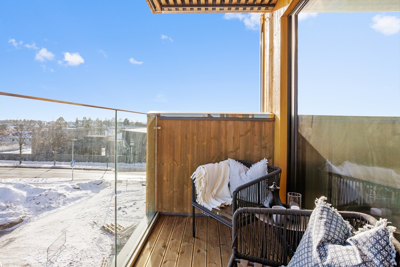 Takoverbygg over hele uterommet sørger for fin skjerming og at balkongen blir et sted å oppholde seg også på våren og høsten. Det er tett rekkverk i kombinasjon av tre og glass som ytterligere fremhever det moderne uttrykket. Galleribilde