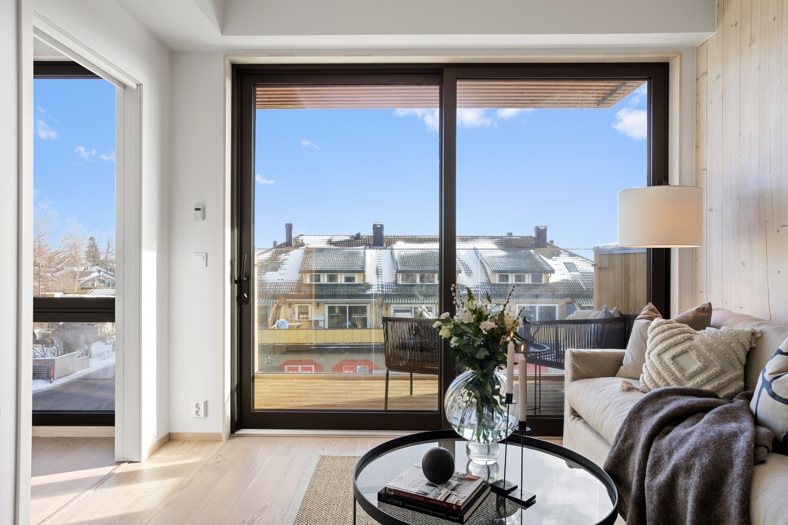 De høye vindusflatene blir nærmest som "møbler" i rommet. Når skyvedøren innerst i oppholdsrommet står åpen mot soverommet, gir dette et "ekstra vindu" til stuesonen. Galleribilde