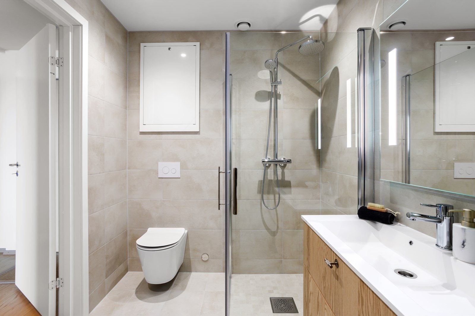 Baderommet er lekkert innredet og har flislagte vegger og flislagt gulv med elektrisk gulvvarme. De varme tonene i både gulvflisene og i veggflisene gir assosiasjoner til "spatema". Galleribilde