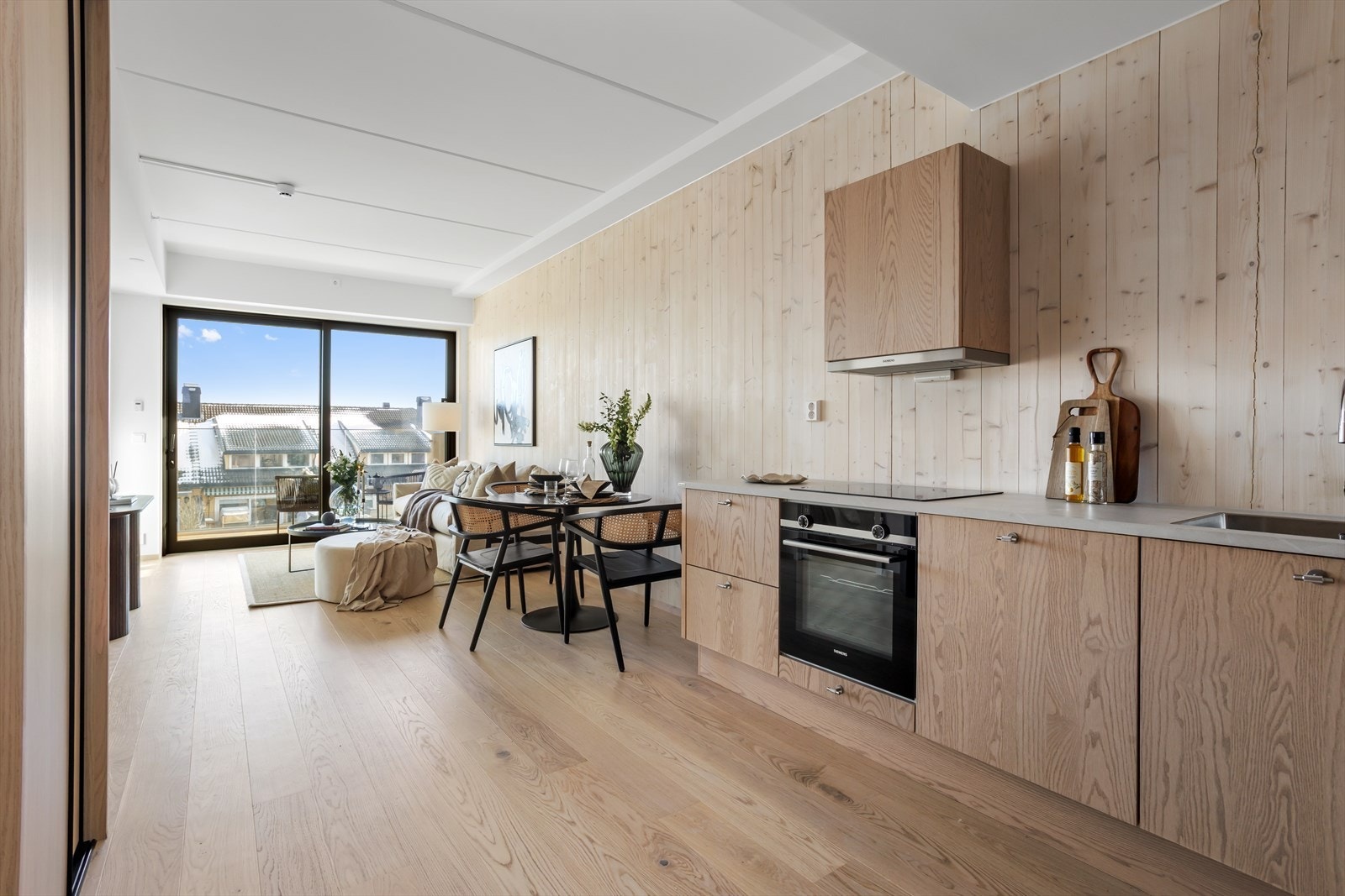 Stuen og kjøkkenet særpreges av å være lys og arealeffektiv hvor romfølelsen forsterkes av de høyreiste vindusflatene og sammenhengen med leilighetens uterom. Skyvedøren leder ut til den fine balkongen hvor du kan nyte utendørslivet og utsikten. Galleribilde