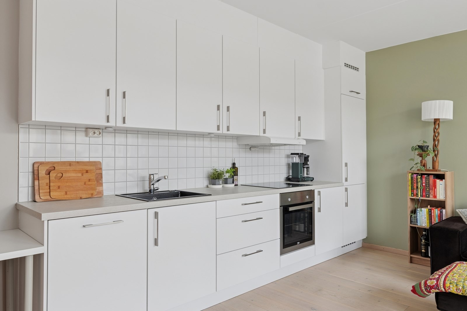 Kjøkkeninnredningen har hvite, slette kjøkkenfronter og integrerte hvitevarer som gir et ryddig og moderne uttrykk. Galleribilde