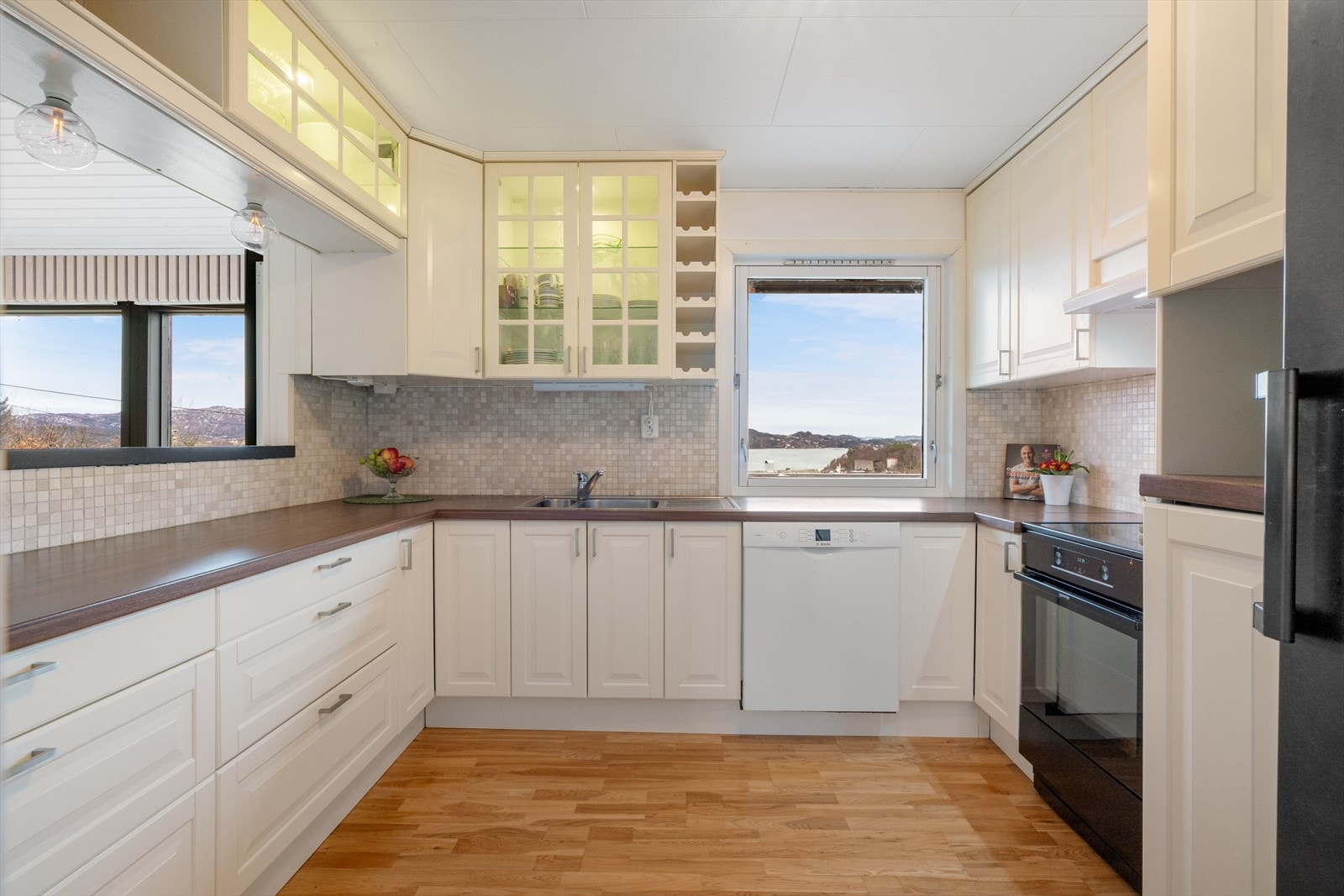 Lyst og velholdt kjøkken med profilerte fronter Galleribilde