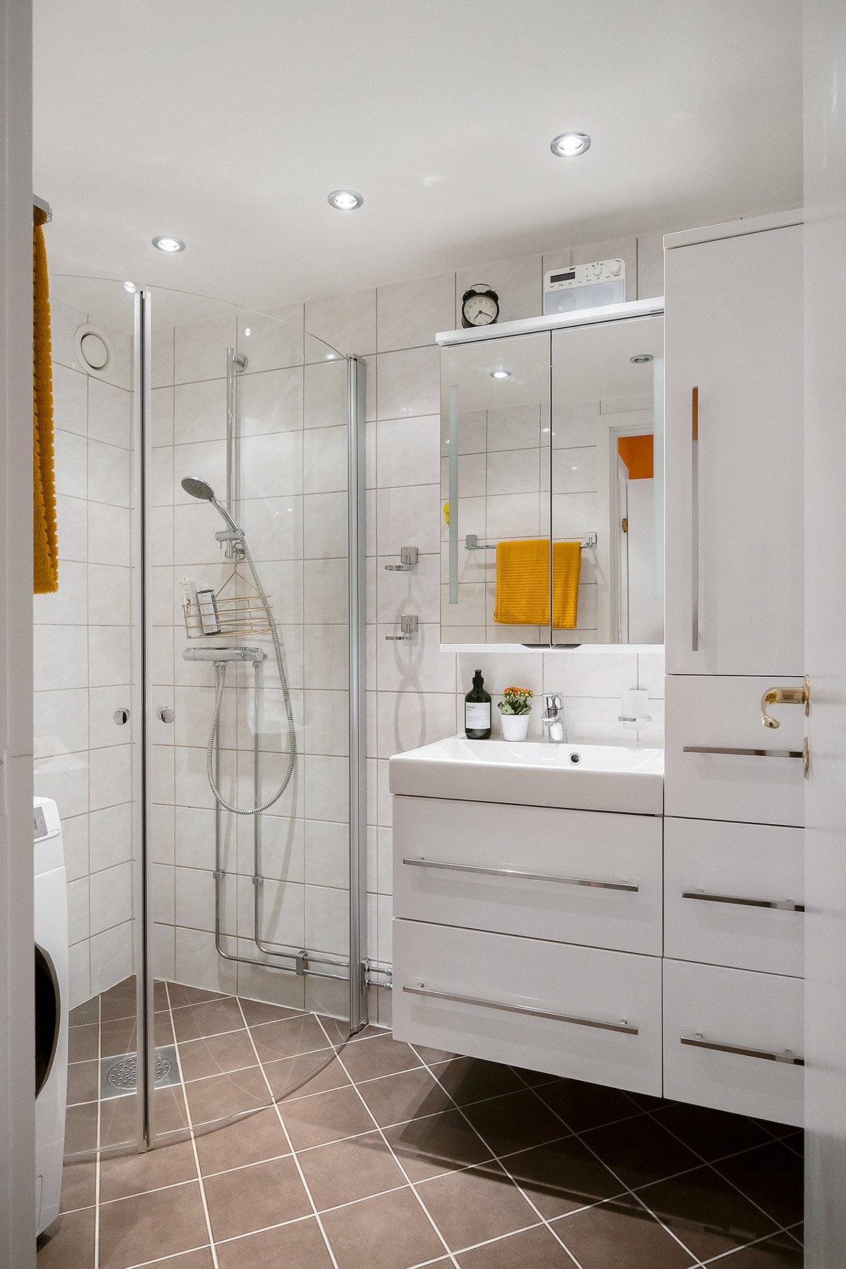 Badet består av buet dusjhjørne, servantinnredning med skuffer og heldekkende servanttopp, speilskap m/lys, høyskap, veggklosett og opplegg for vaskemaskin Galleribilde