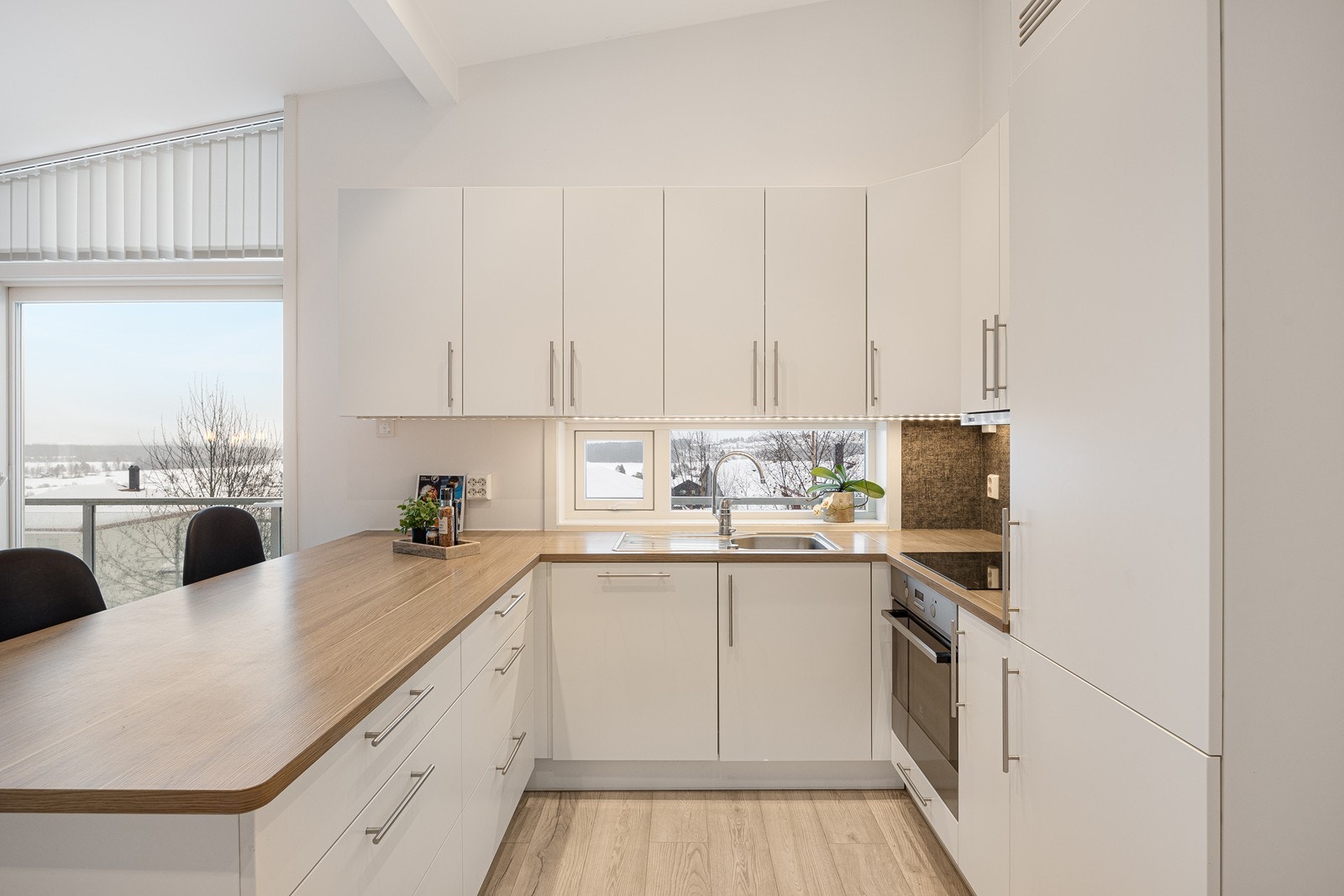 Innredningen har hvite, glatte fronter og laminatbenkeplate med nedfelt oppvaskkum. Galleribilde