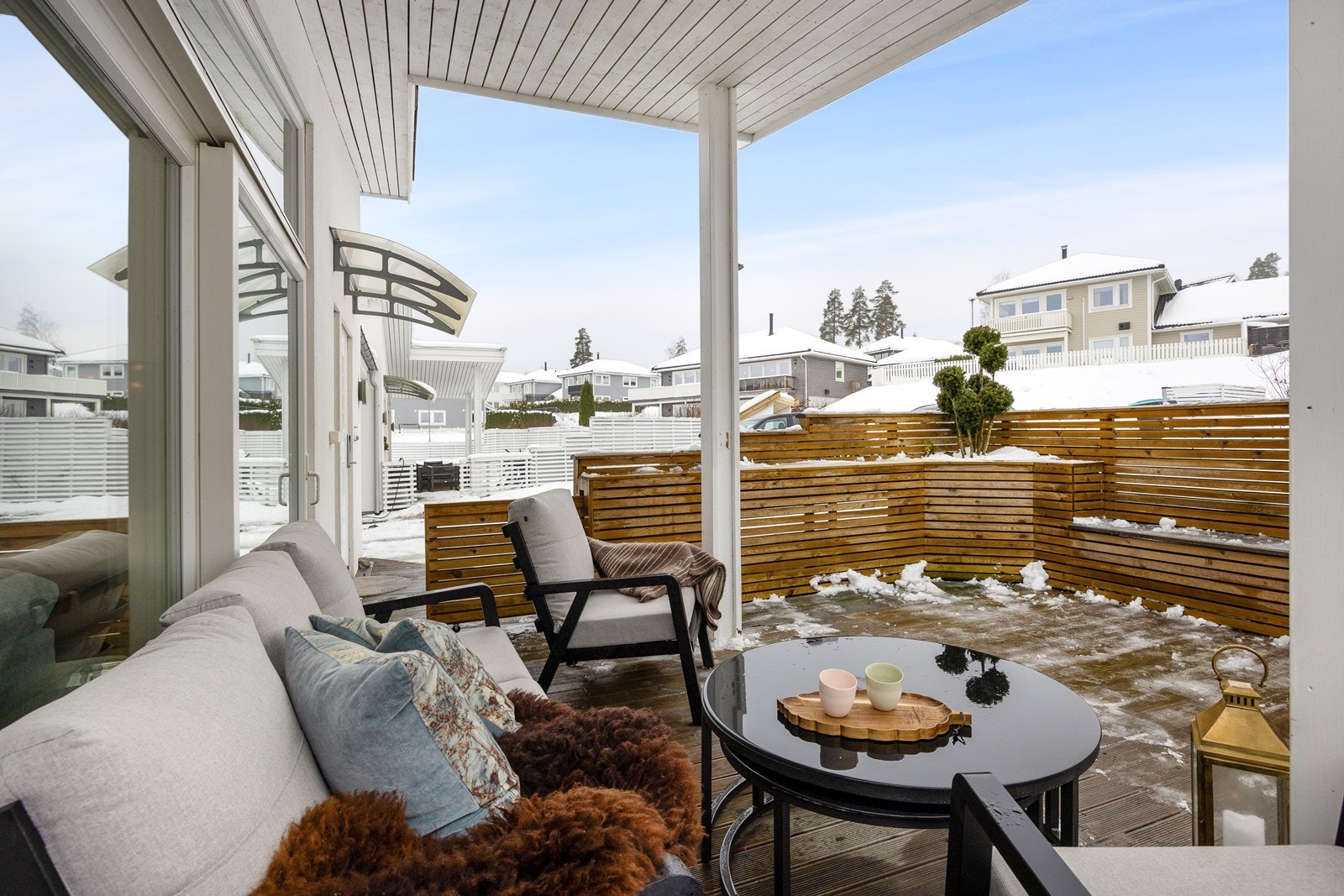 Den delvis overbygde terrassen ved inngangspartiet er pent opparbeidet med flotte innebygde blomsterkasser og sitteplasser. Galleribilde