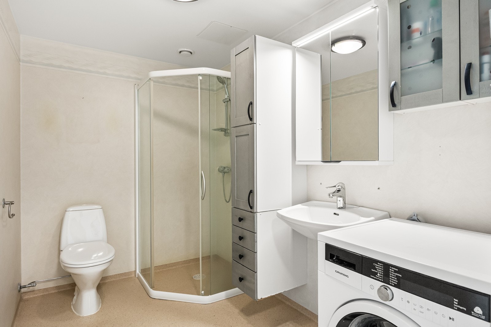 Badet er utstyrt med dusjhjørne, servant og elektrisk gulvvarme. I tillegg opplegg for vaskemaskin Galleribilde