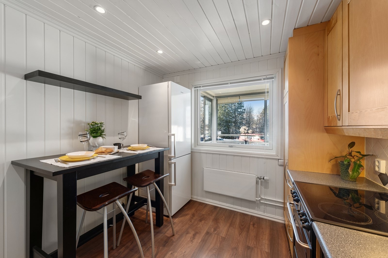 Innredningen har nisjer til frittstående hvitevarer som komfyr, kjøleskap og oppvaskmaskin. Over komfyren er det en kjøkkenventilator med kullfilter. Galleribilde