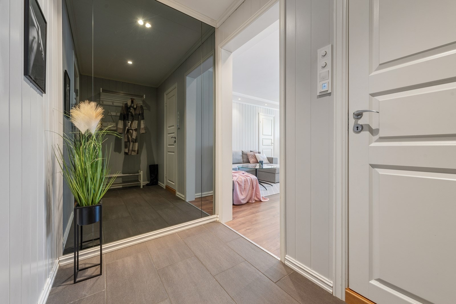 Entréen har pent laminatgulv og lyse vegger. Galleribilde