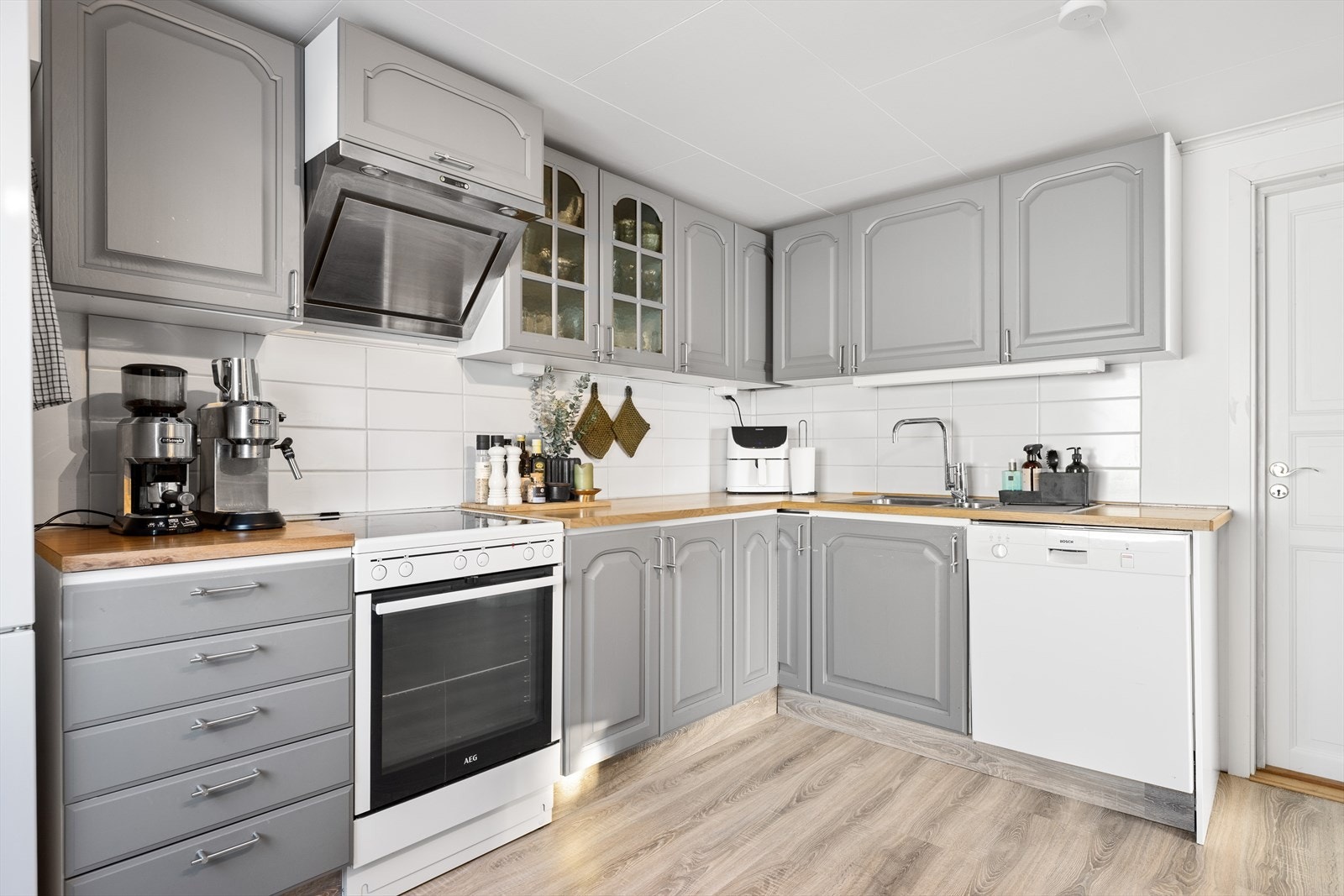 Pent kjøkken med profilerte dører og laminat benkeplate Galleribilde