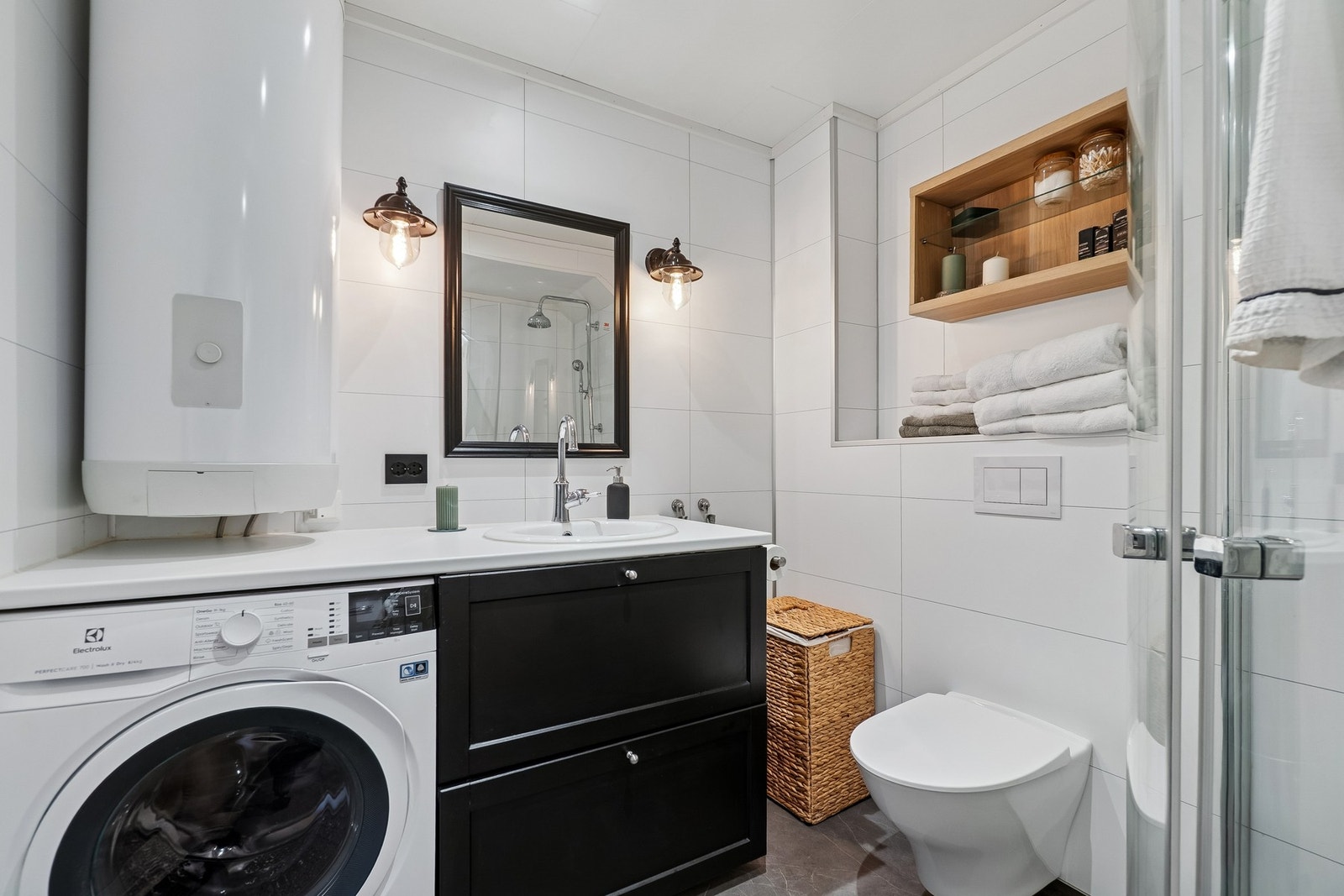 Badet er utformet med et nøytralt grått gulv mens veggene er lyse våtromsplater. Galleribilde