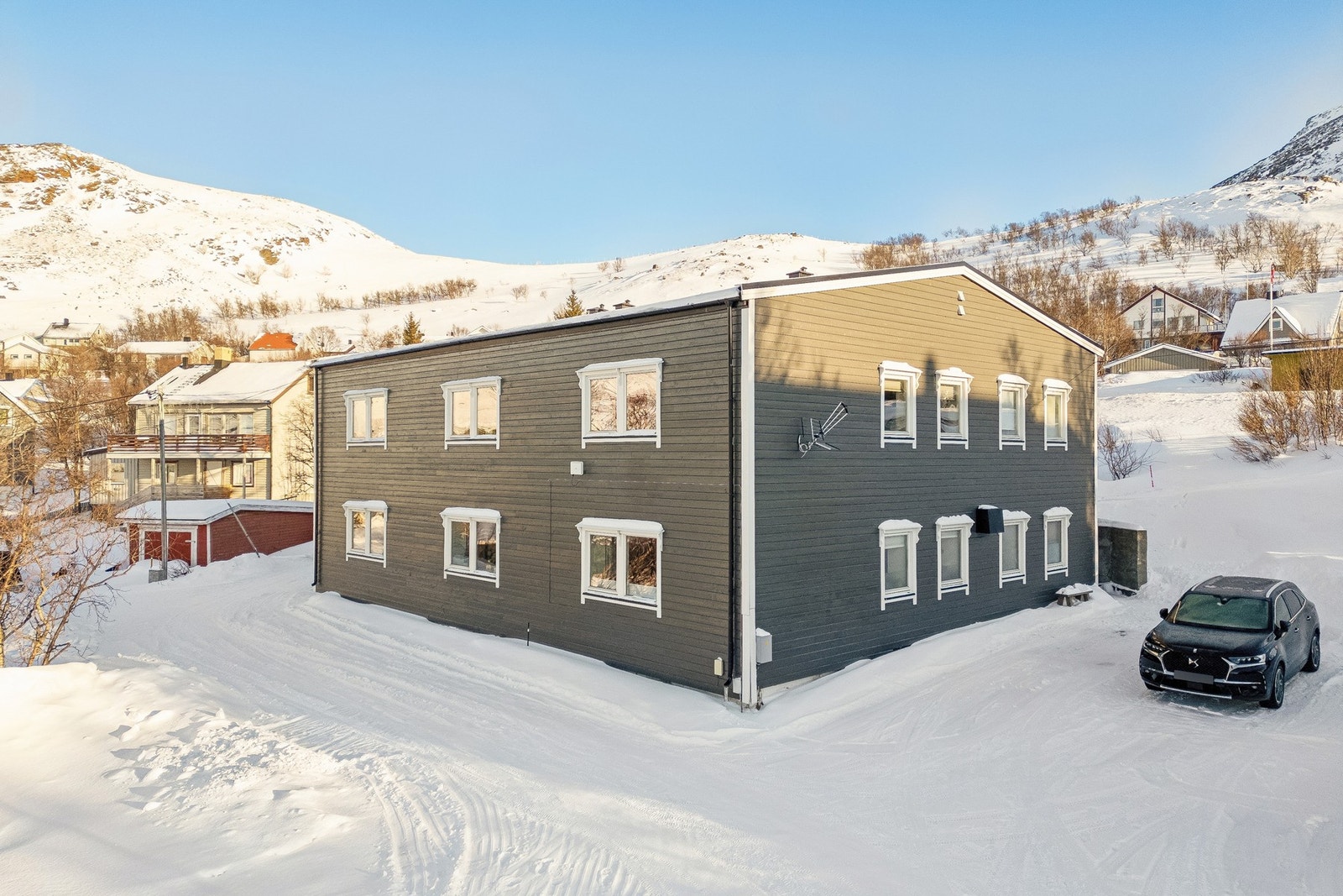 Boligens har adkomst fra et felles overbygd inngangsparti (i bakkant) med oppstillingsplass for bil like ved. Galleribilde