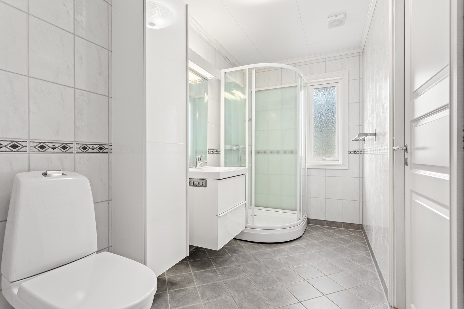 Flott bad med flislagt golv med varmekablar og baderomsplater på vegger. Galleribilde