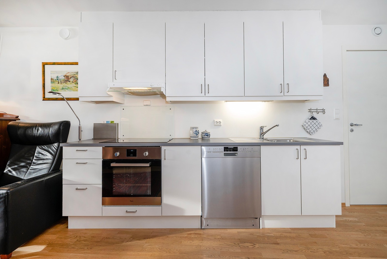 Integrert komfyr og med platetopp i benkeplaten, og det er opplegg for oppvaskmaskin. Galleribilde