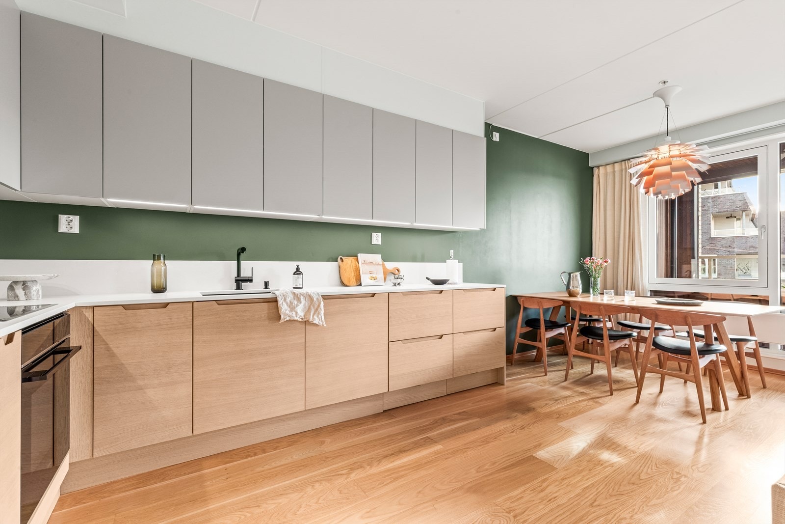 Innredningen har slette fronter og komposittsten benkeplate (oppgradert i 2022) med underlimt kum. Kjøkkenet er utstyrt med integrert kjøl/frys, oppvaskmaskin, stekeovn og induksjonstopp, samt mekanisk avtrekk fra ventilator og komfyrvakt. Galleribilde