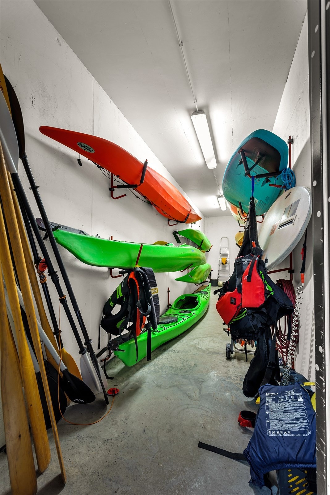 Kajakkbod med flere kajakker, supbrett og tilhørende utstyr. Fri bruk ved å betale et enkelt årskontigent. Galleribilde