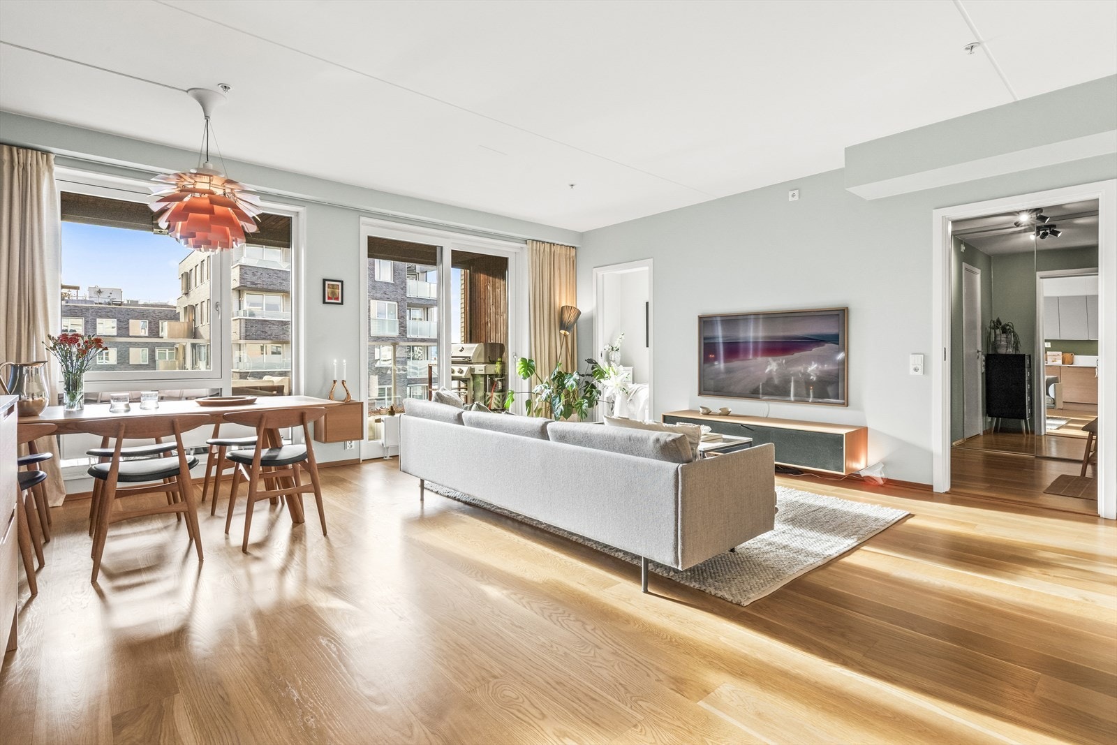 Store vindusflater fra gulv til tak, samt balkongdør, slipper inn rikelig med naturlig lys og skaper en luftig atmosfære. Galleribilde