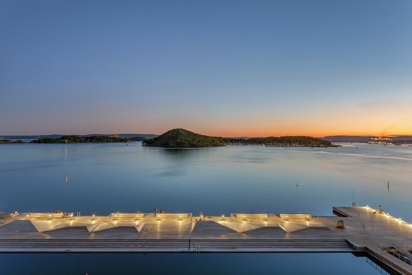 Dette er ikke bare en av byens mest populære badeplasser - området forvandles også til noe helt magisk når kvelden senker seg, med rolig stemning, glitrende vann og vakre solnedganger. Galleribilde