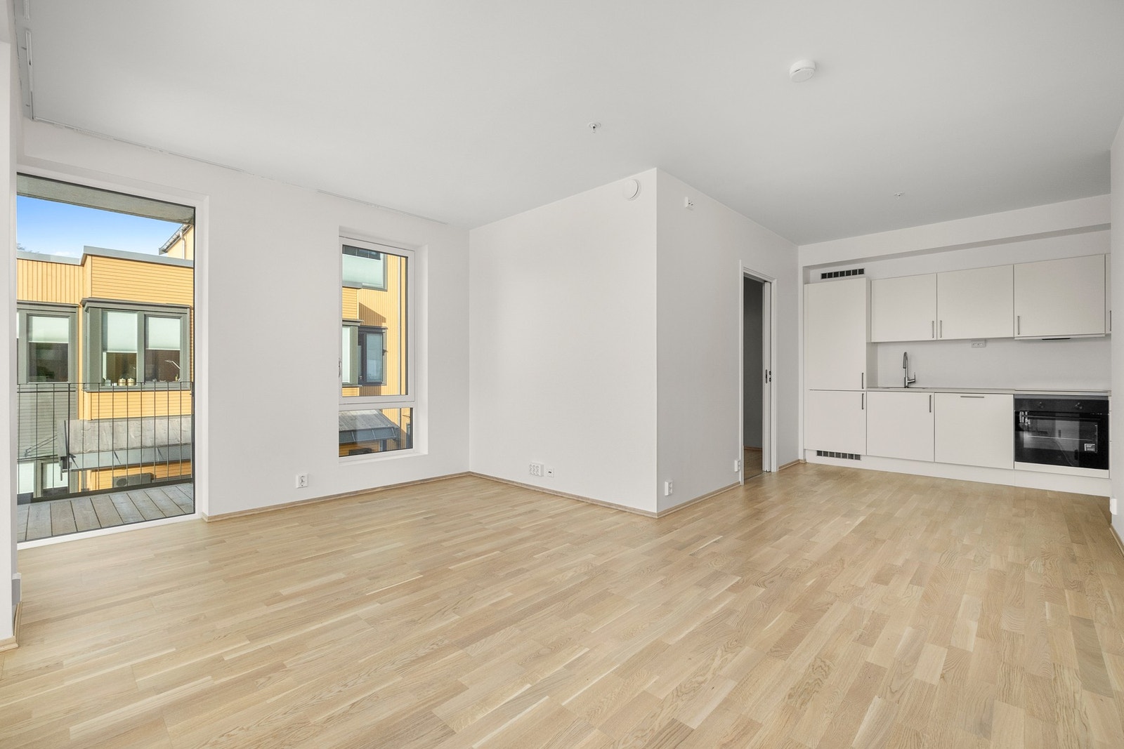 Romslig stue kjøkken løsning som er naturlig avdelt Galleribilde