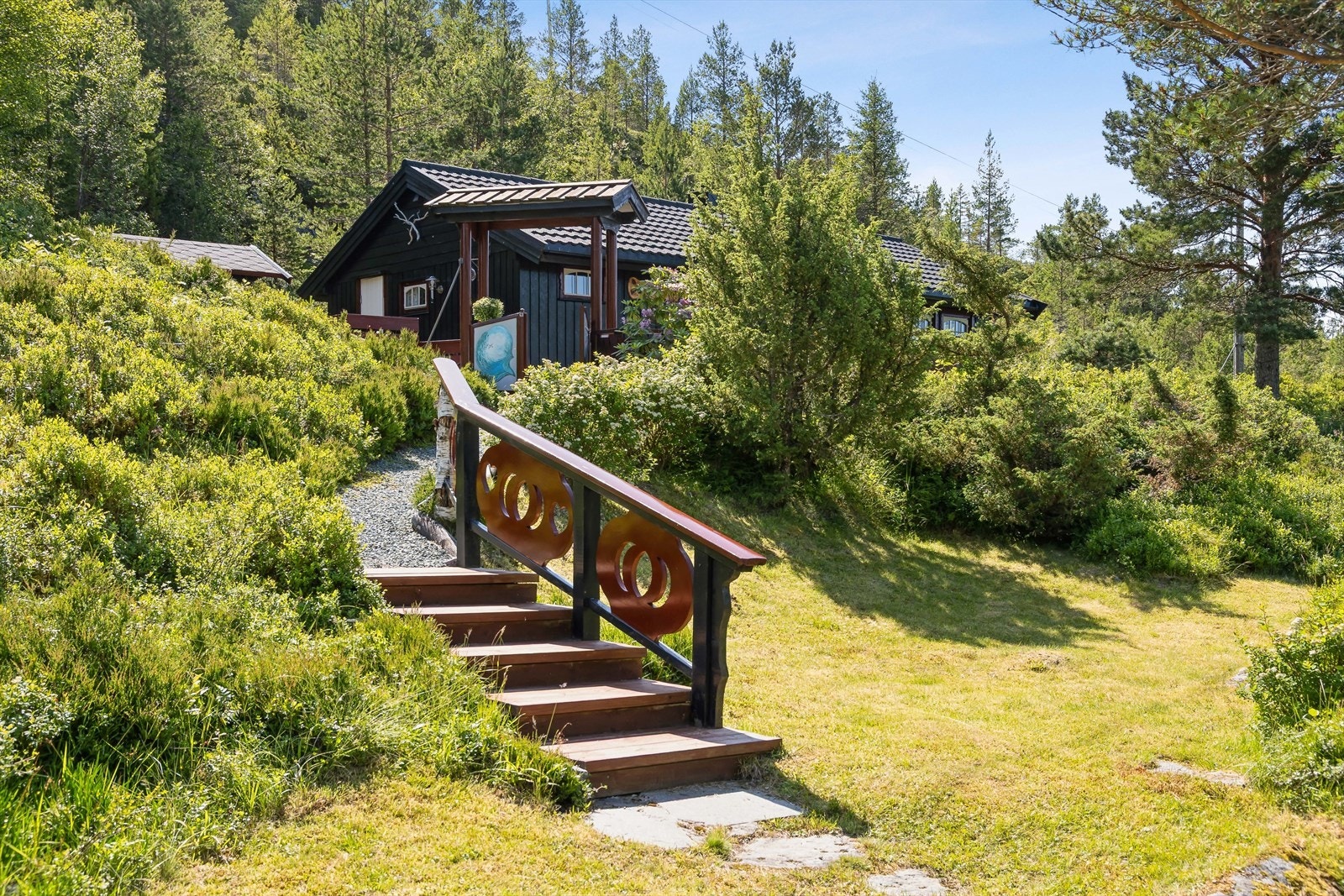 Eiendommen er pent opparbeidet med sti opp til hytten. Det er mulighet til å plukke blåbær og tyttebær på egen tomt. Galleribilde