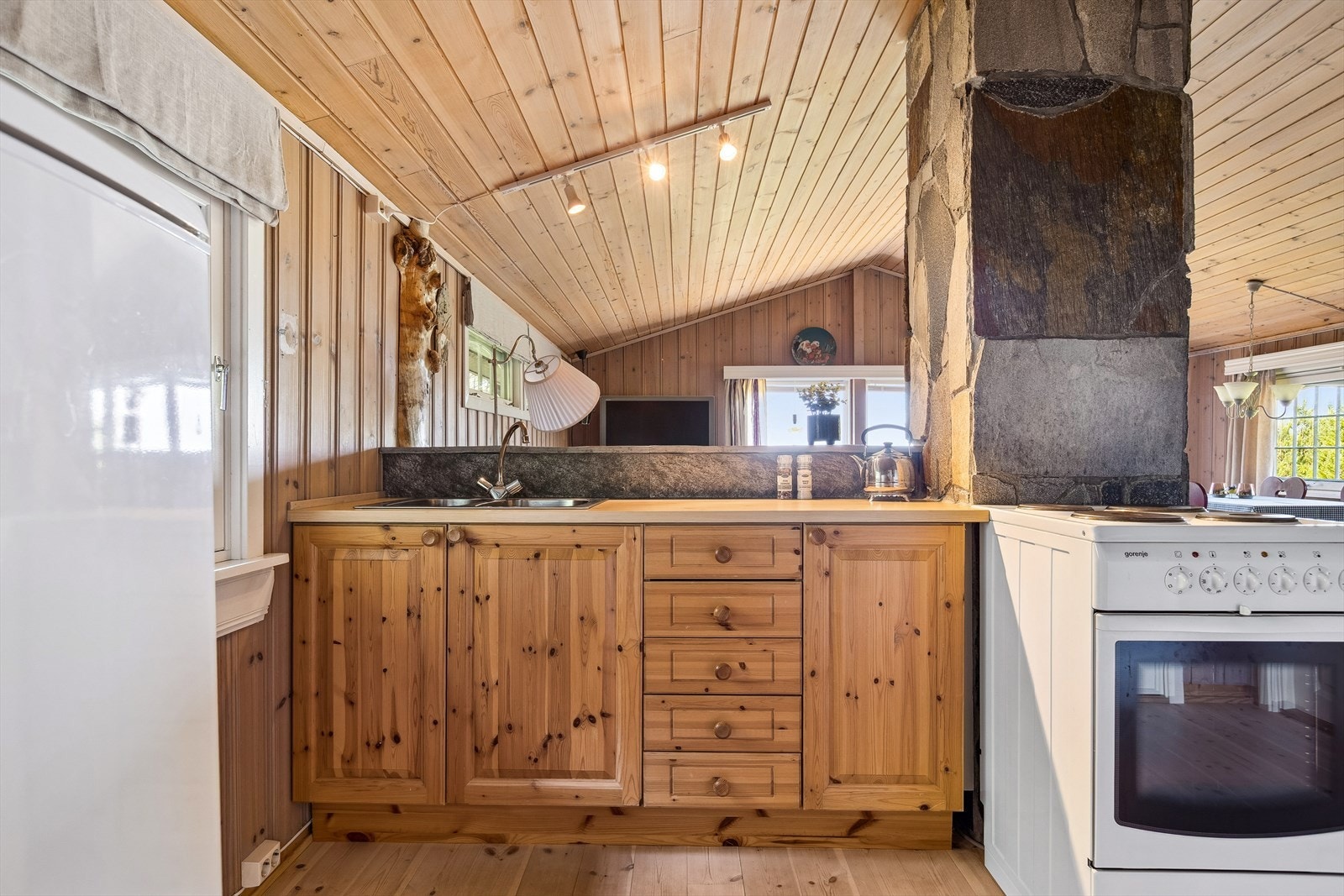 Heltre kjøkken med vask, kjørleskap og komfyr. Galleribilde