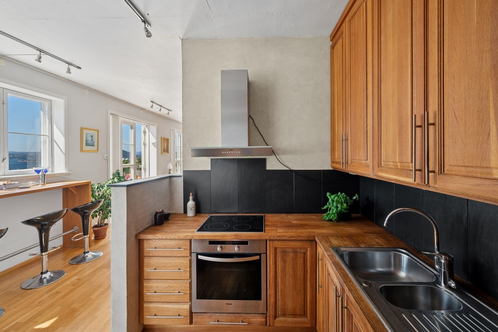 Kjøkkenet ligger i en delvis åpen løsning mot hovedstuen i første etasje. Kjøkkeninnnredningen er av noe eldre dato, med profilerte heltre fronter og benkeplate i heltre eik. Galleribilde