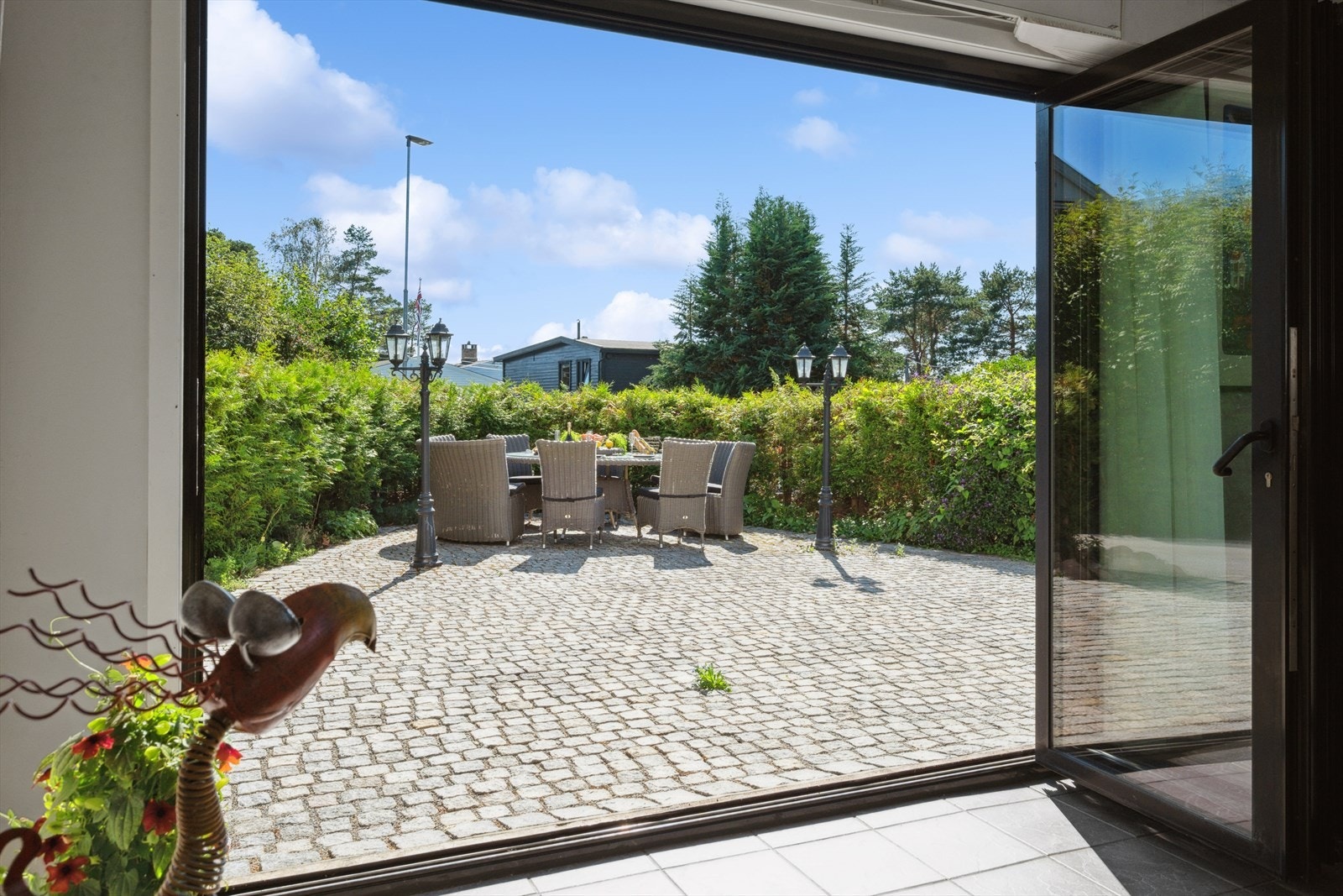 Den innfellbare terrassedøren åpner opp mot den steinbelagte uteplassen, som gjør rommet ideelt som sommerstue. Galleribilde