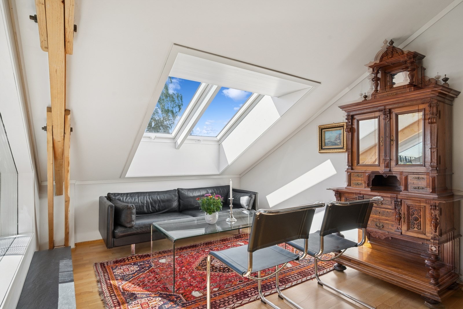 Lys og innbydende loftstue med skråtak og store takvinduer. Galleribilde