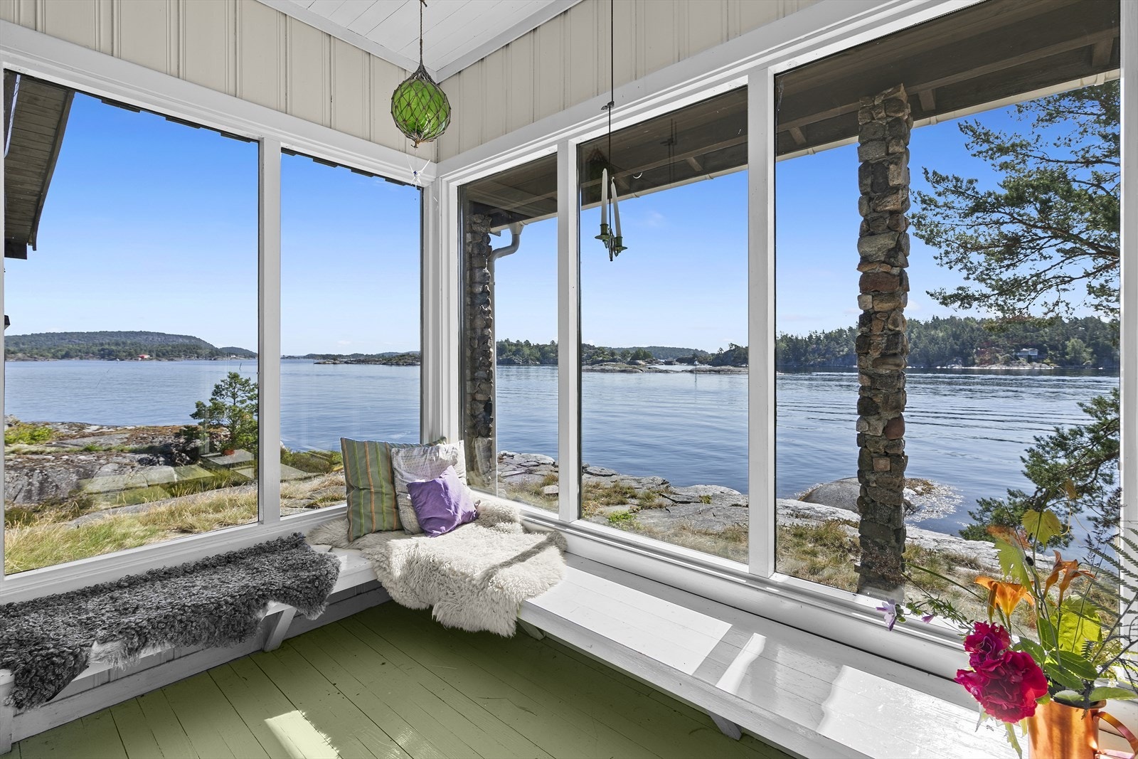 Det er lang sittebenk ved de store vinduene og utsikten. Galleribilde