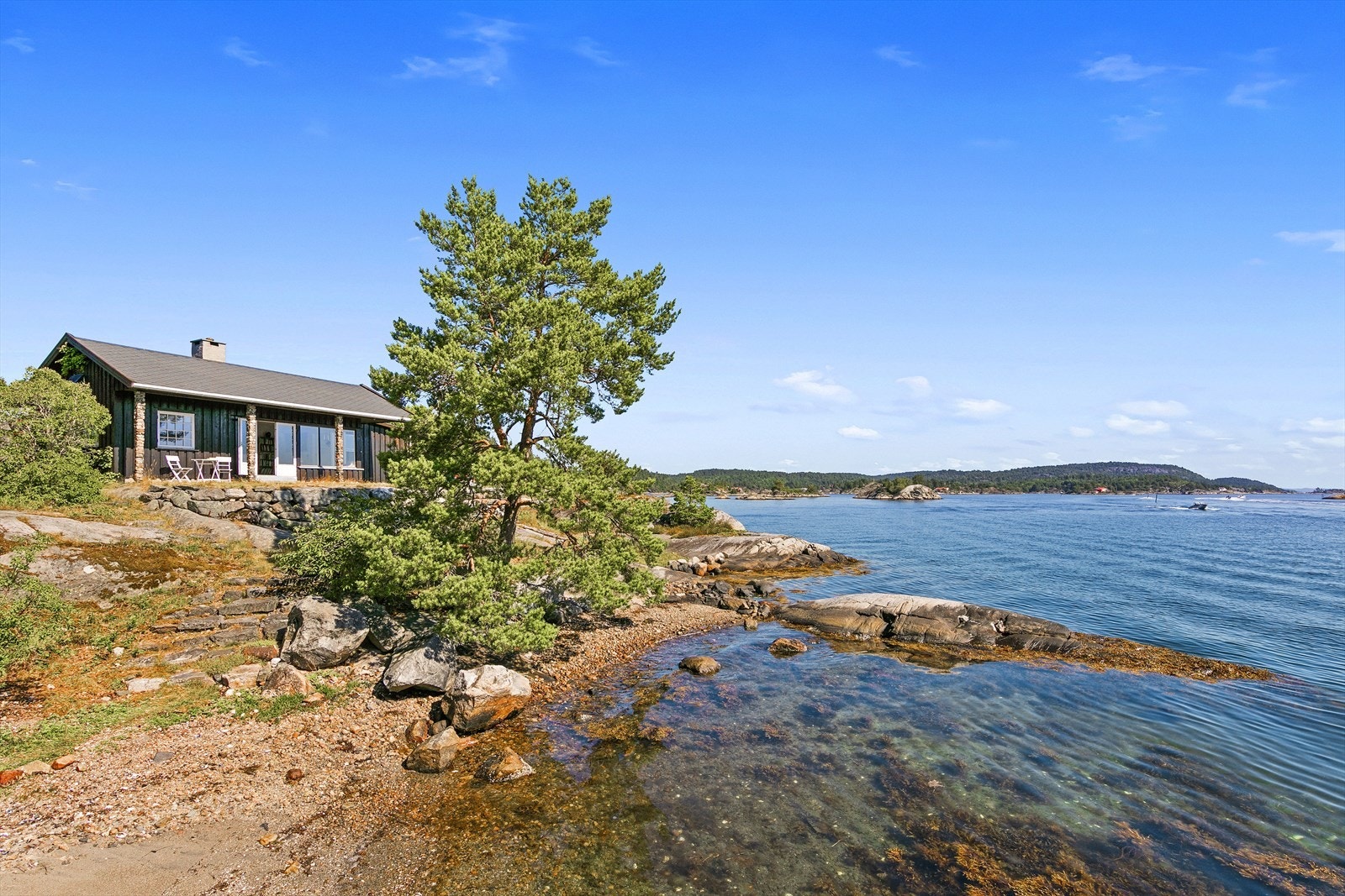 Fra uteplassen er det steintrapper ned til stranda. Galleribilde