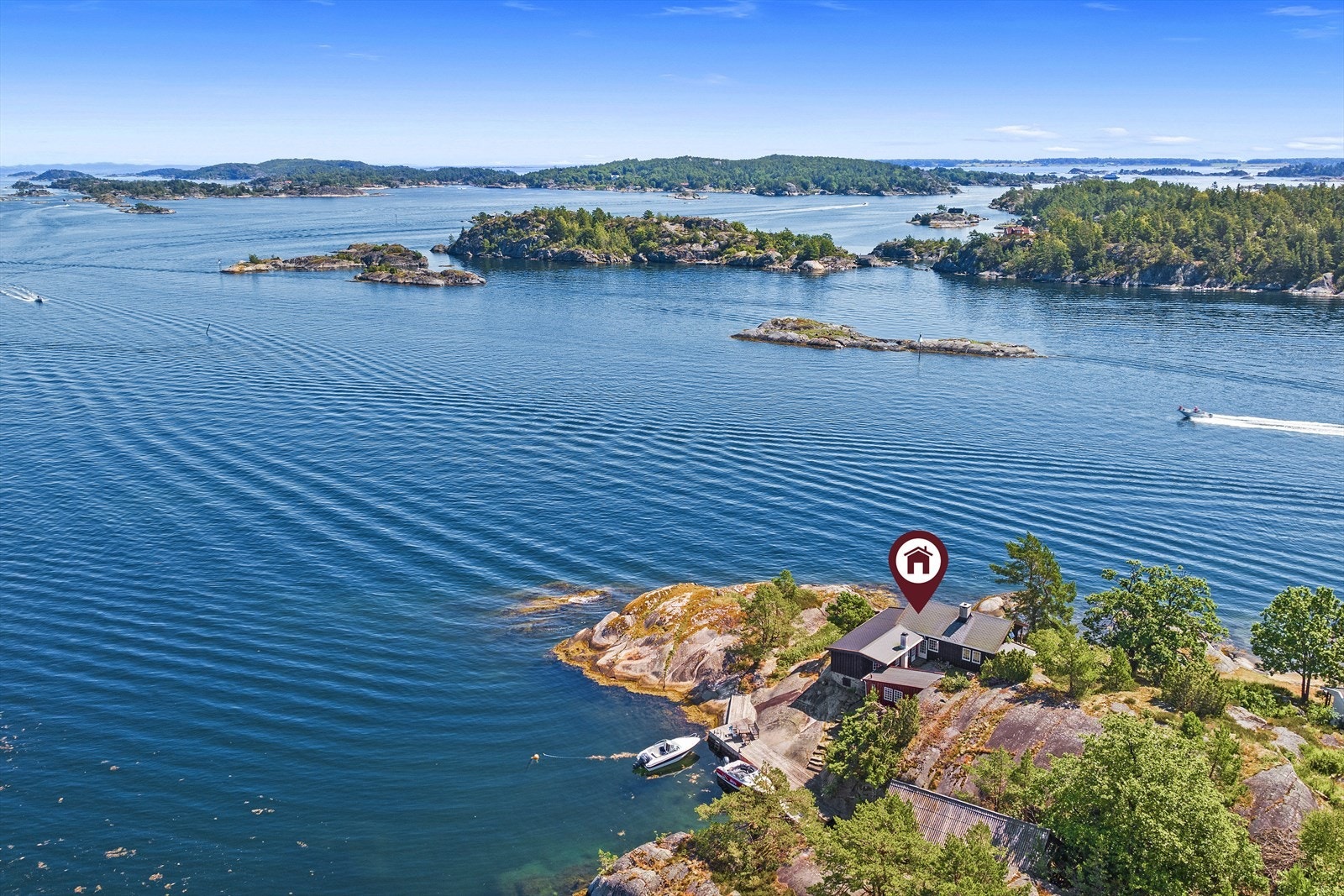 Formen på hytta sammen med sjøboden danner et lunt uterom eller atrium mellom byggene. Galleribilde