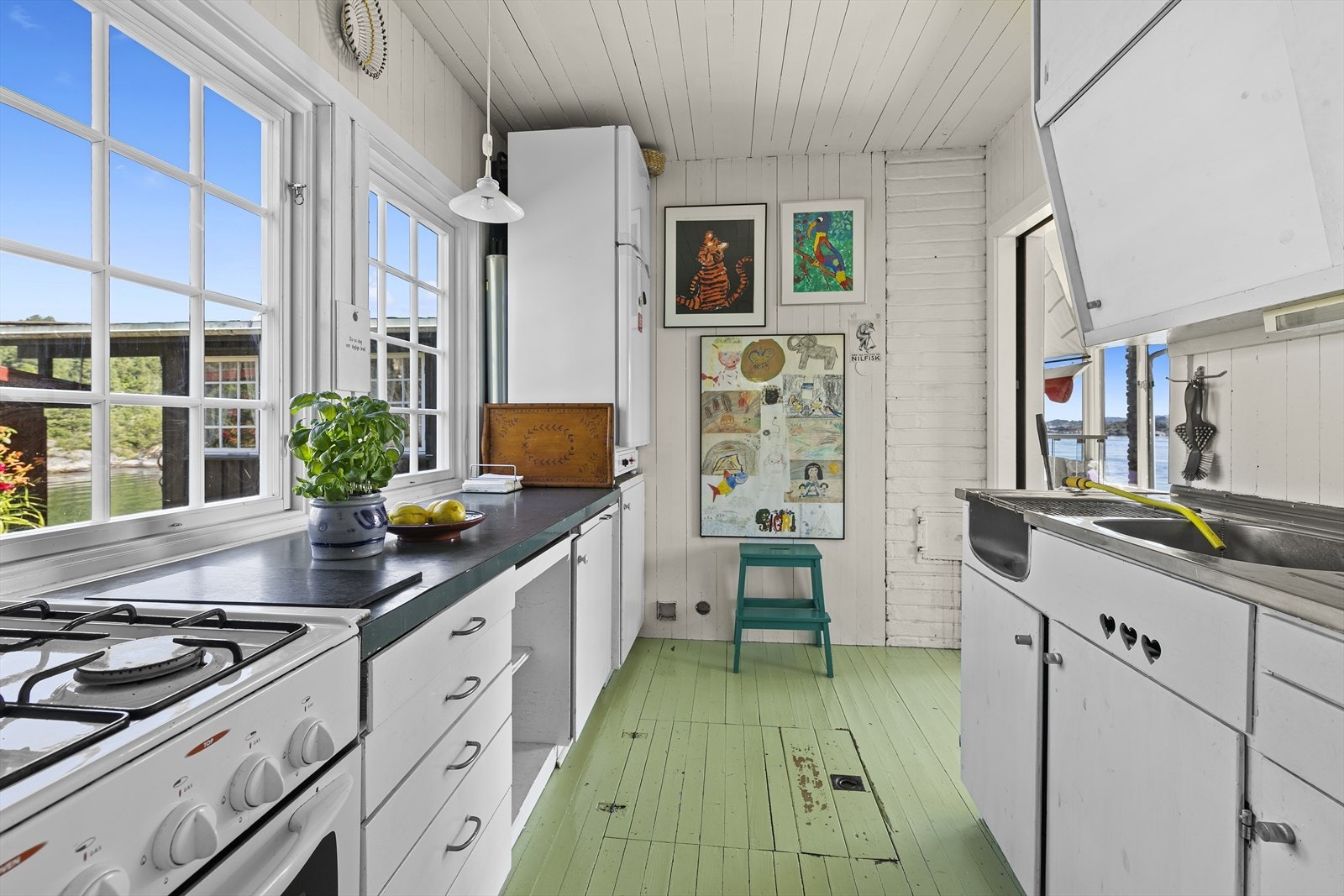 Innenfor stua er det kjøkken, som har innredning i tre med glatte fronter Galleribilde