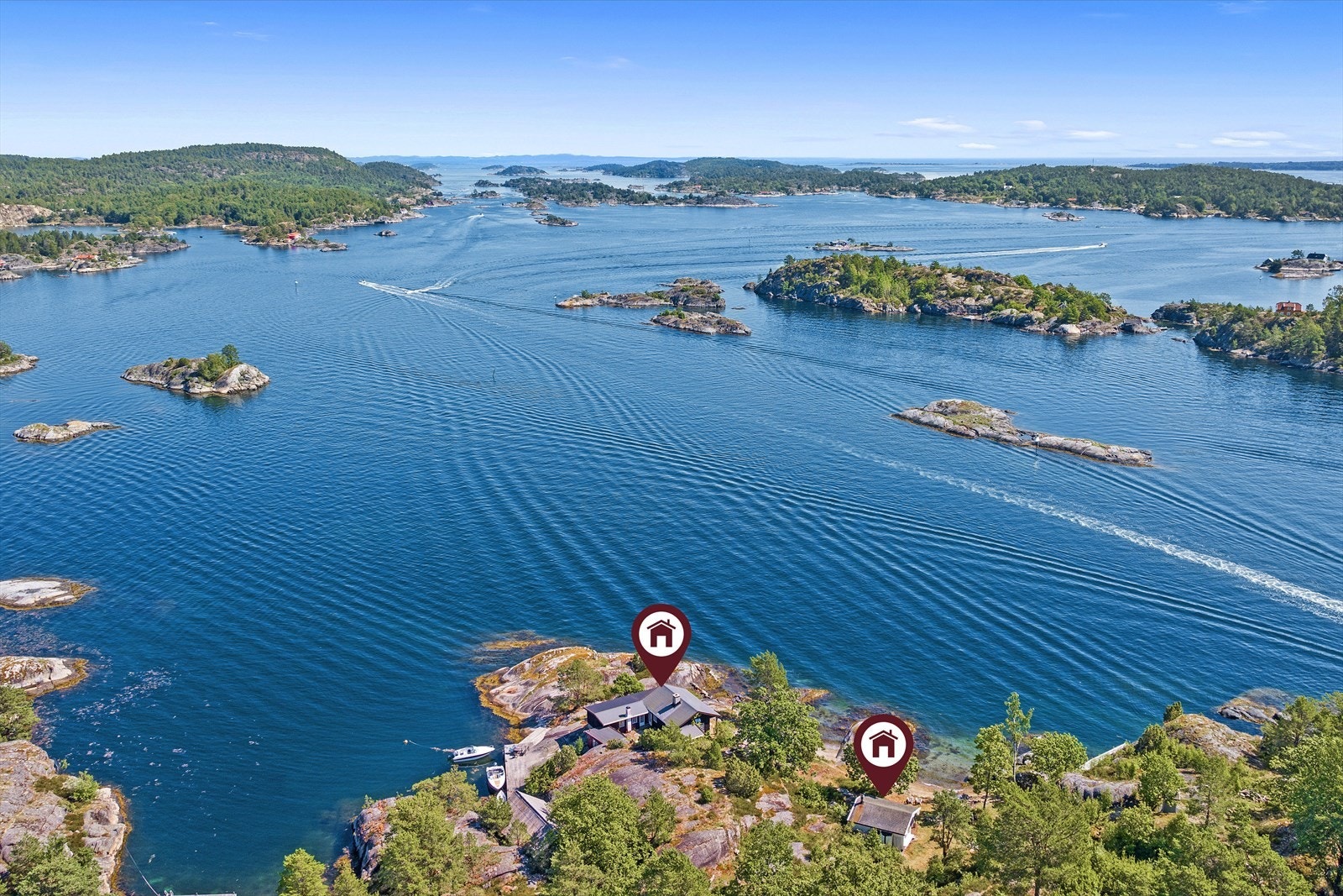 Hovedhytta ligger ute på en odde med brygge på den ene siden, sandstrand på den andre og svaberg og havet i front. Galleribilde
