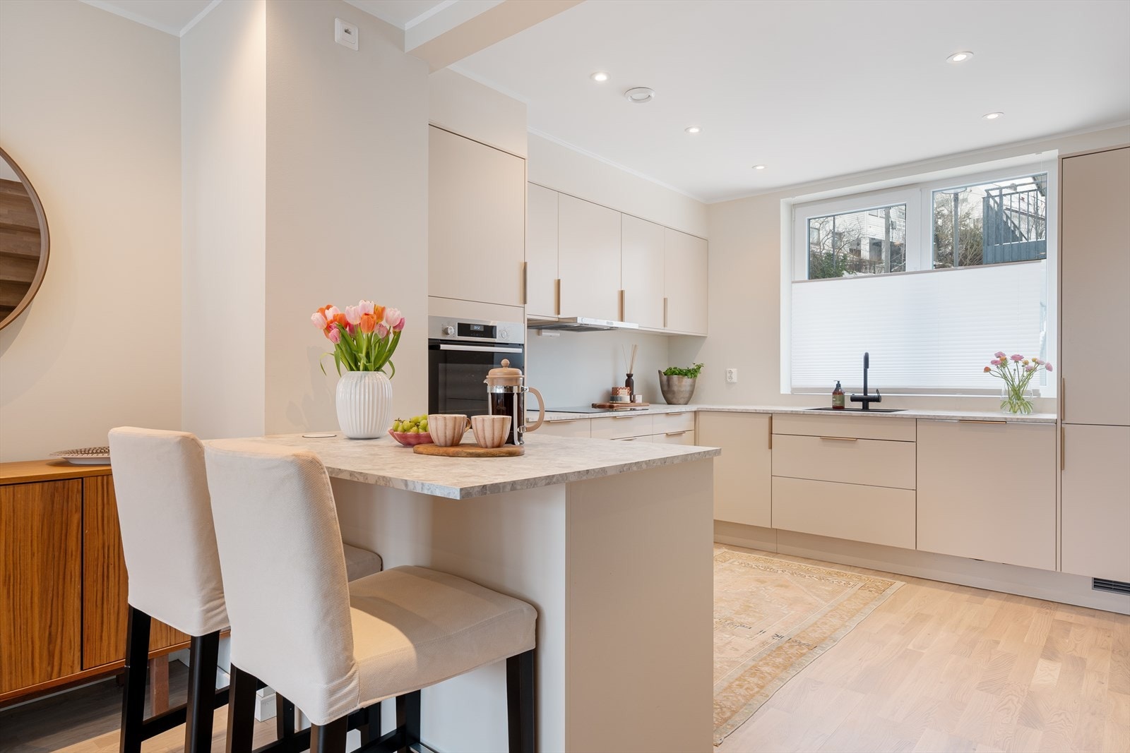 Den varme fargen på kjøkkeninnredningen er i tonen "kaffe og krem". En nydelig kombinasjon med resten av leiligheten som er malt i Jotun Frostrøyk. Galleribilde