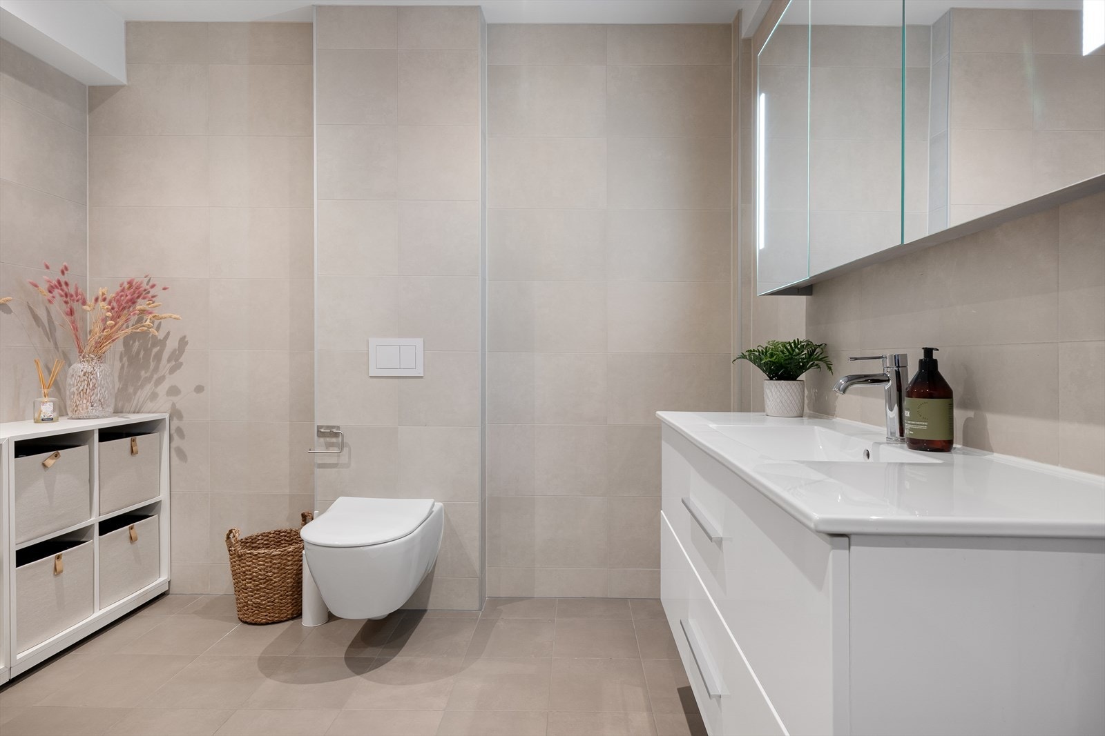 Tidløs og lekker innredning med hvit skuffeseksjon og overskap med speilfronter. Integrert makeup lys. Galleribilde