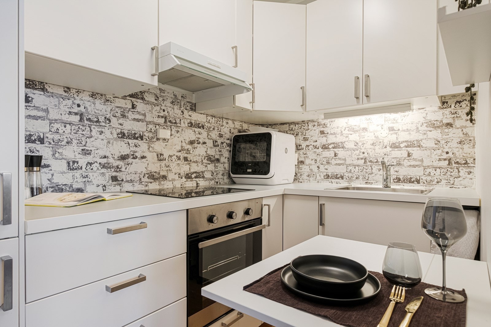 Lys kjøkkeninnredning med laminat hvite glatte fronter. Galleribilde